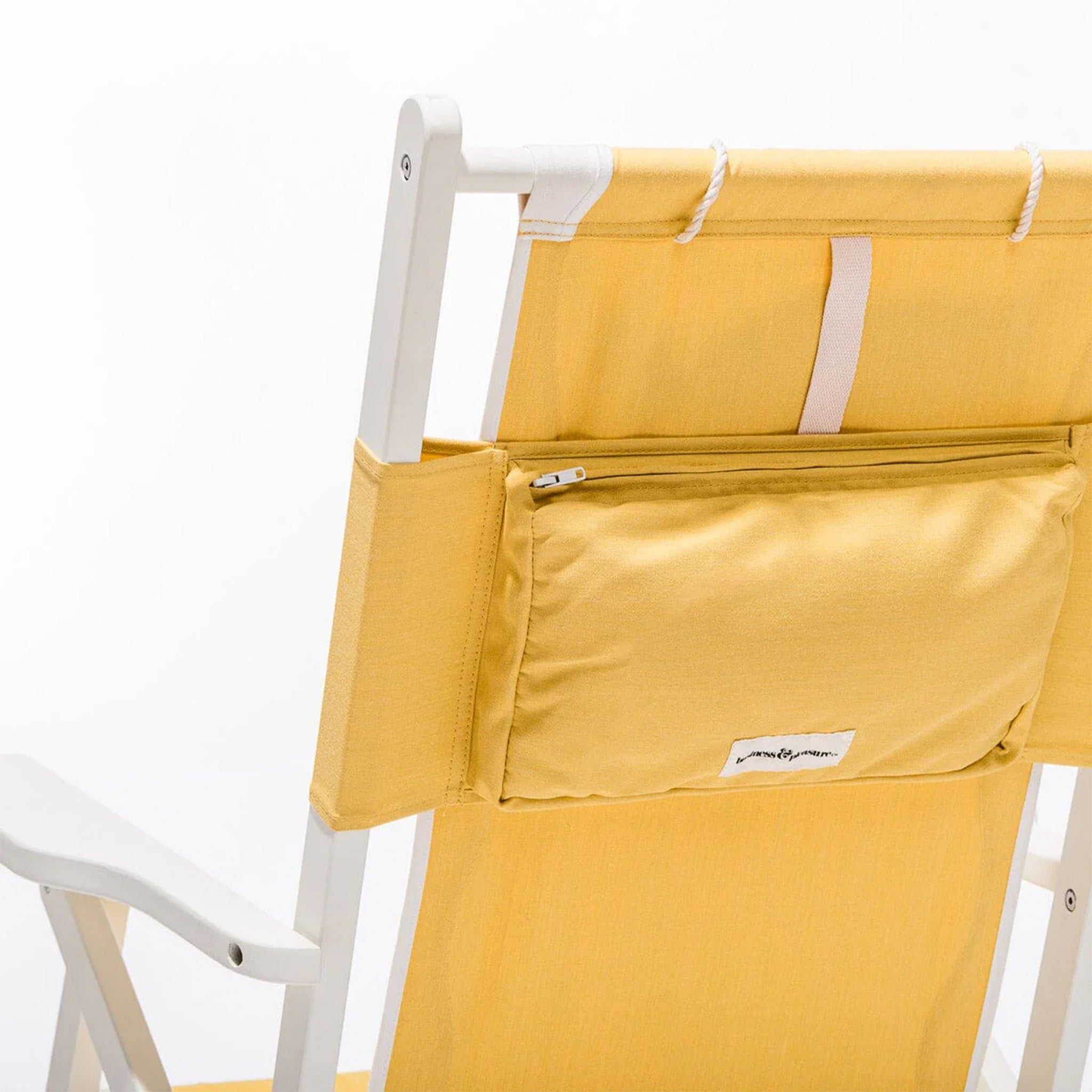 A white and yellow folding beach chair with a zip back pocket and a headrest pillow.