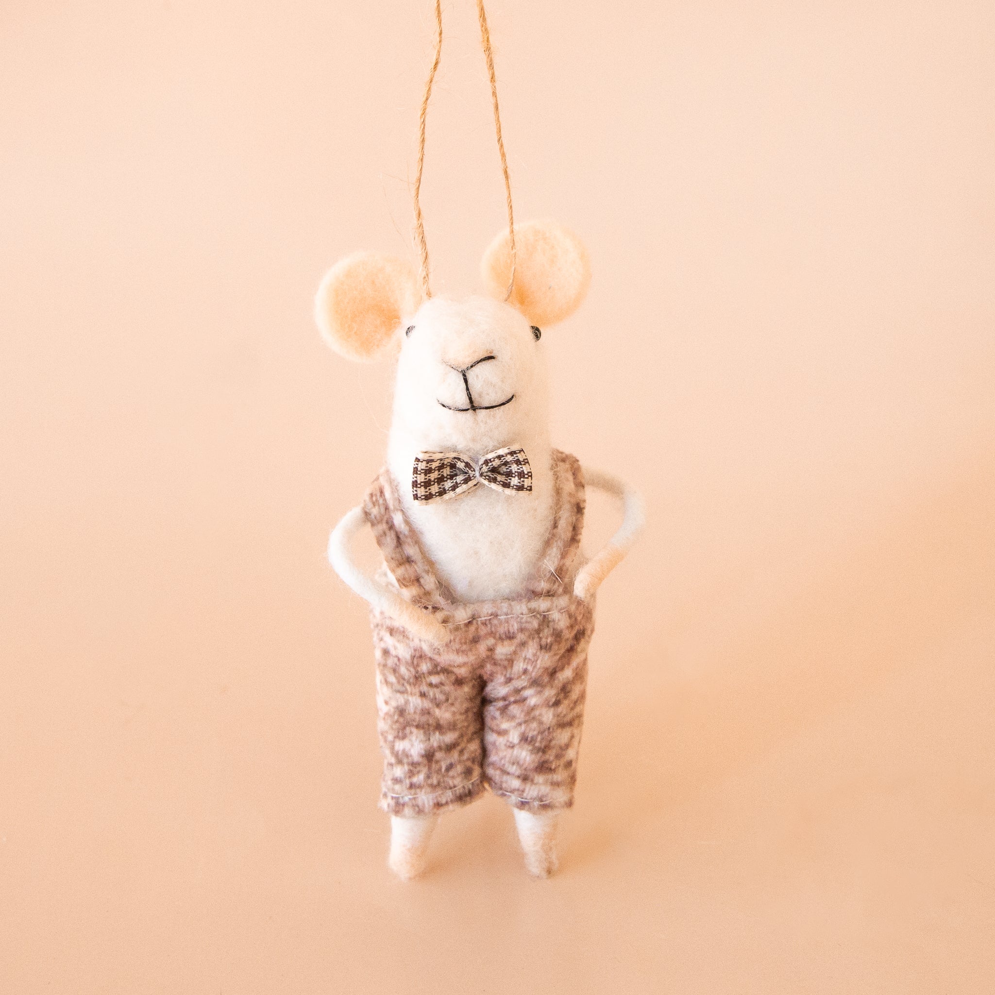 A mouse shaped ornament wearing a bowtie and suspenders. 