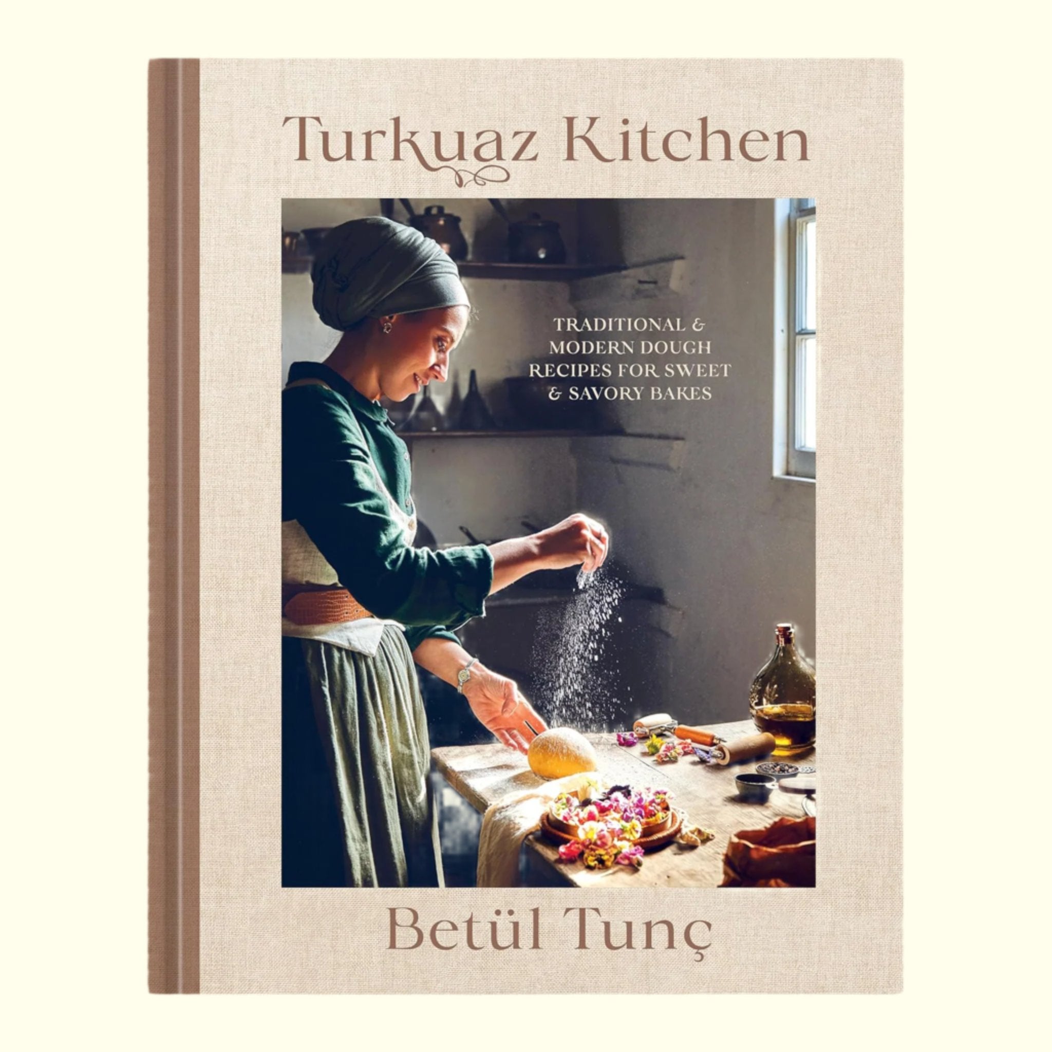 A tan and brown book cover with a chef cooking in the kitchen and text above that reads, 'Turkuaz Kitchen'. 