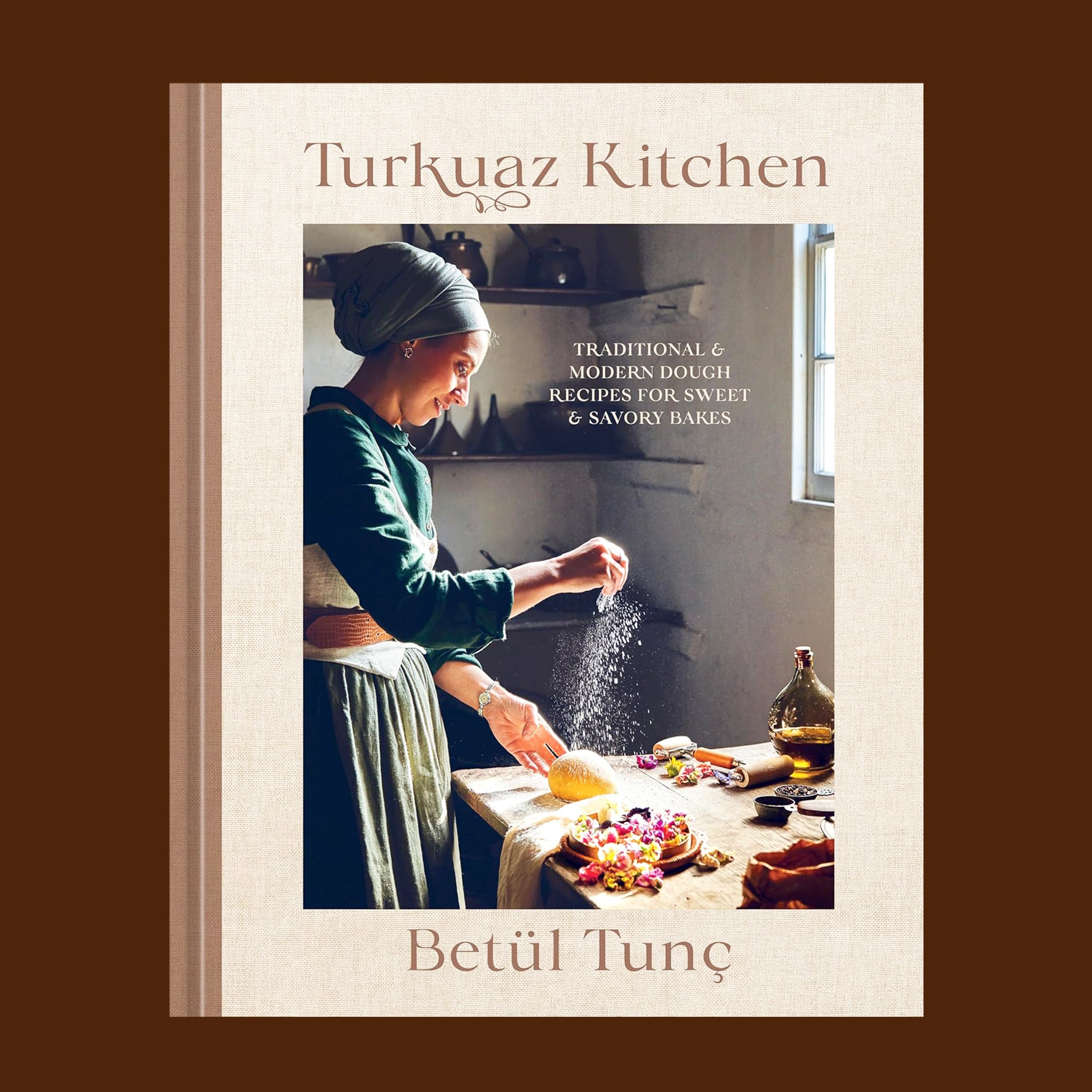 A tan and brown book cover with a chef cooking in the kitchen and text above that reads, 'Turkuaz Kitchen'. 