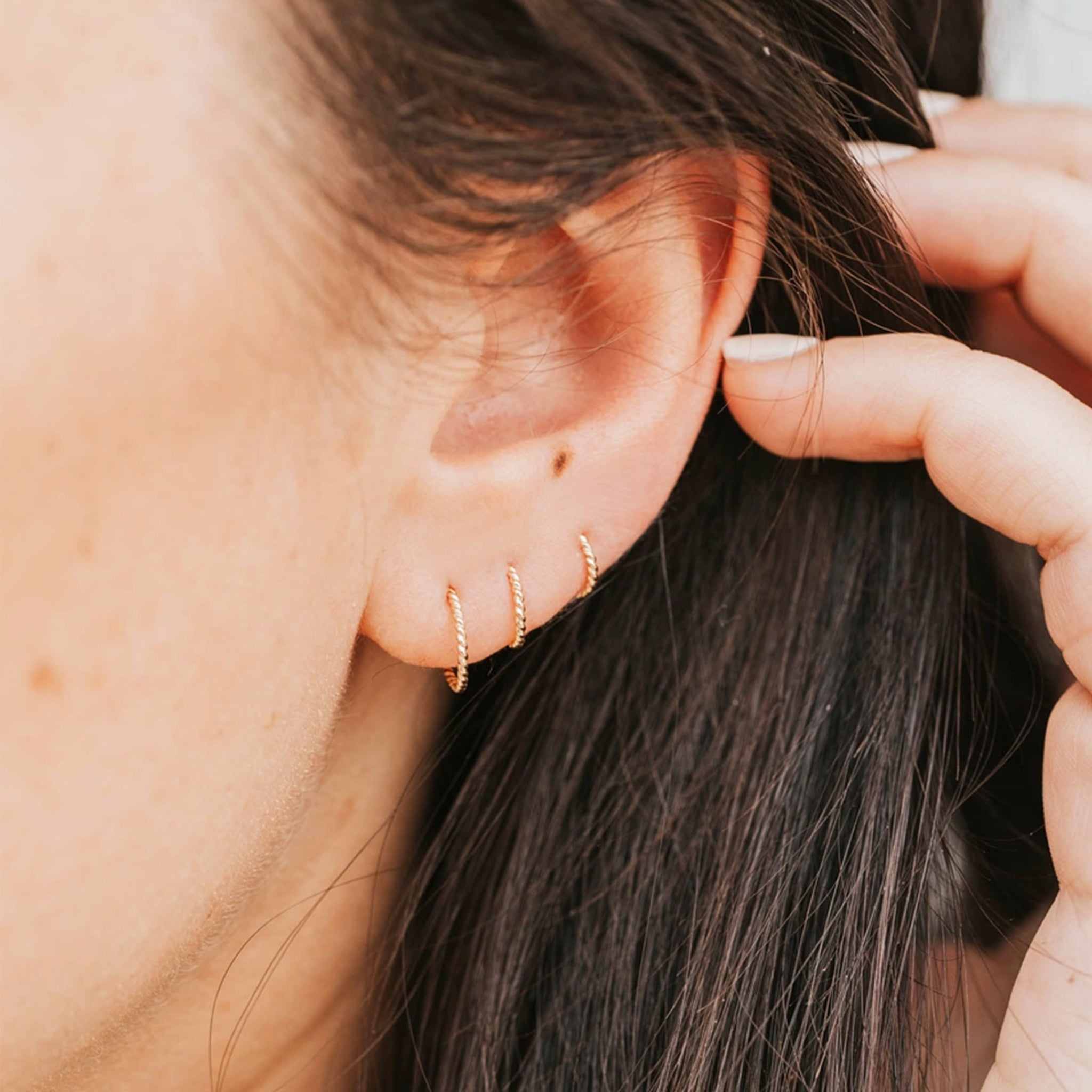 Multiple sizes of twisted hoop earrings. 