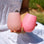 A pair of two pink and peachy silicone stemless wine glasses for on-the-go beverages. 