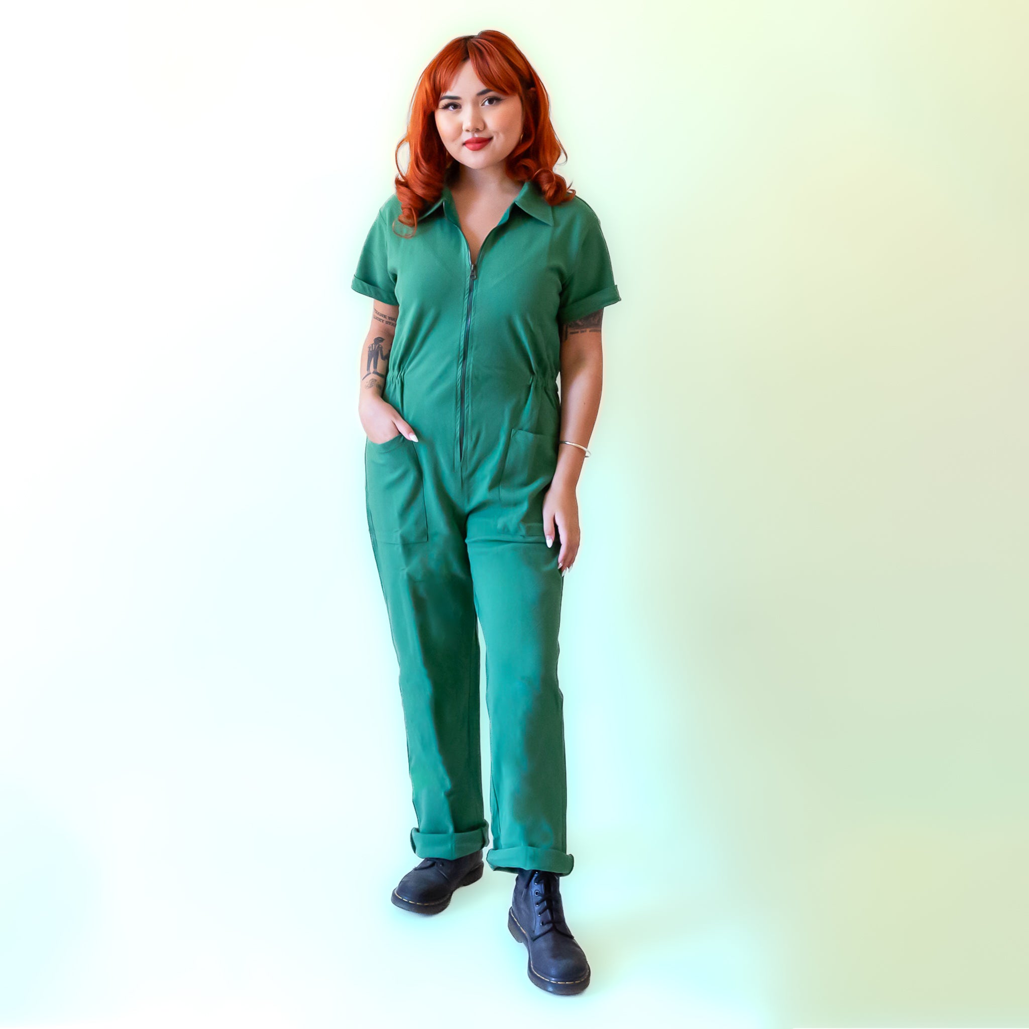 A green short sleeve jumpsuit with a zipper up the front. 