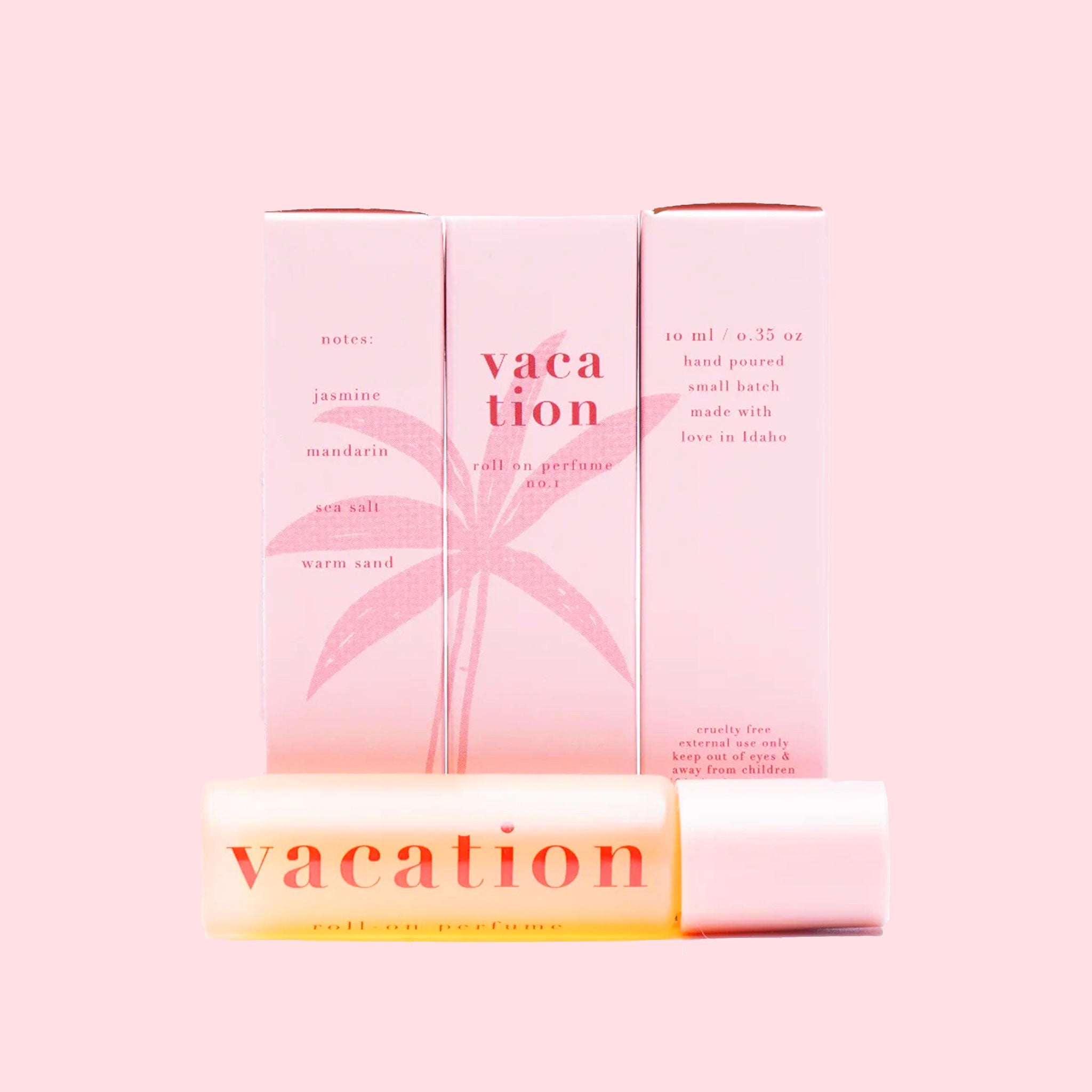 In front of a pink background is a small clear glass bottle with black top. Around the middle is white wrap with an orange circle and light orange palm leaf. On top is black text that reads ‘vacation.’ To the left is a rectangular shaped box. It is mostly orange with a little stripe of light pink and white at the top. There is black text at the top that reads ‘vacation.’ In the middle is a light pink palm leaf.