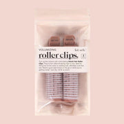 On a white background is a set of volumizing roller clips in their pink packaging. 