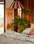 A multi colored woven wall hanging with a thin rope hanging.