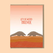 A orange sunset shaded card with text that reads, 'Let's be weird together' along with an illustration of two pangolins. 