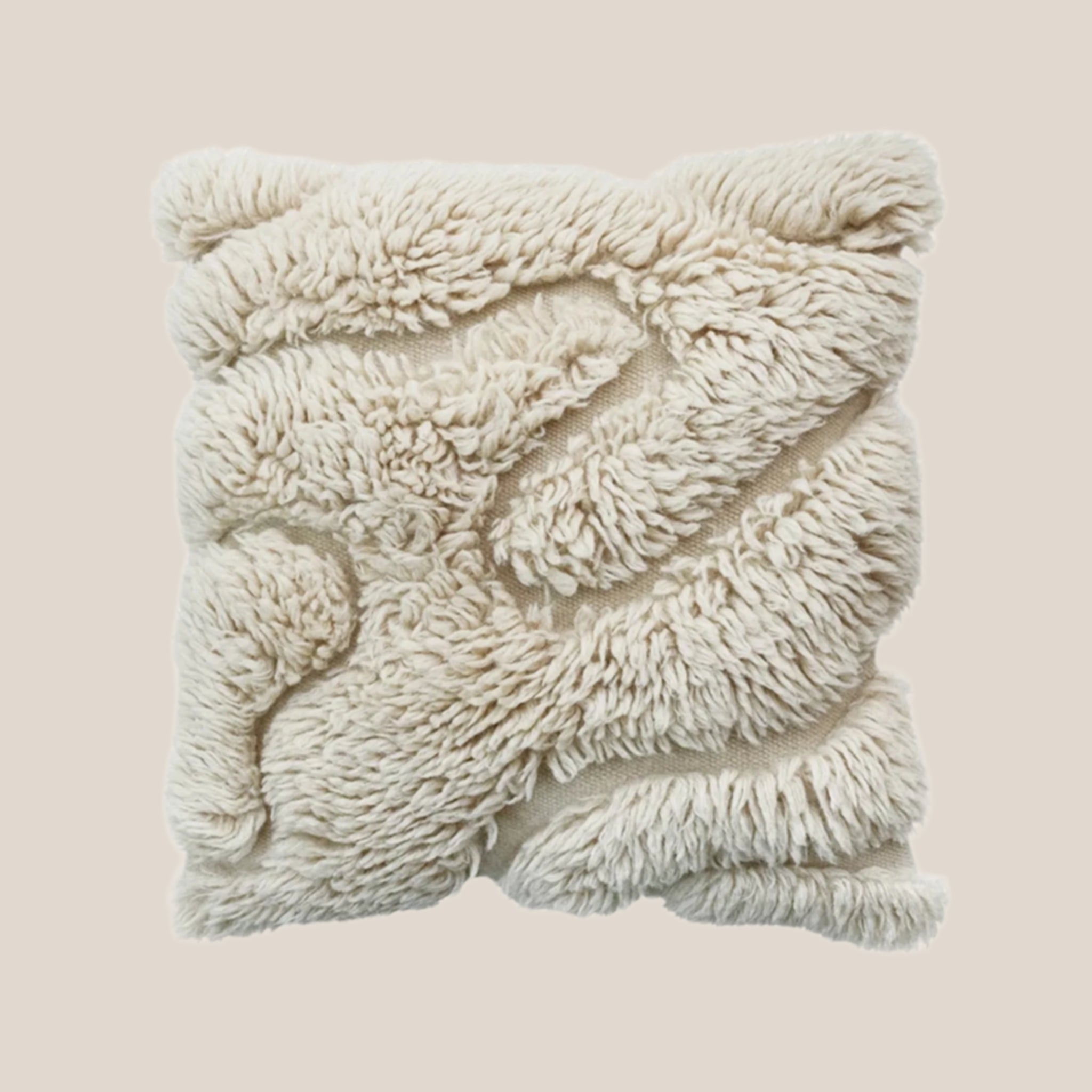 A square, cream colored cotton shag pillow with a wavy design within the shag. 