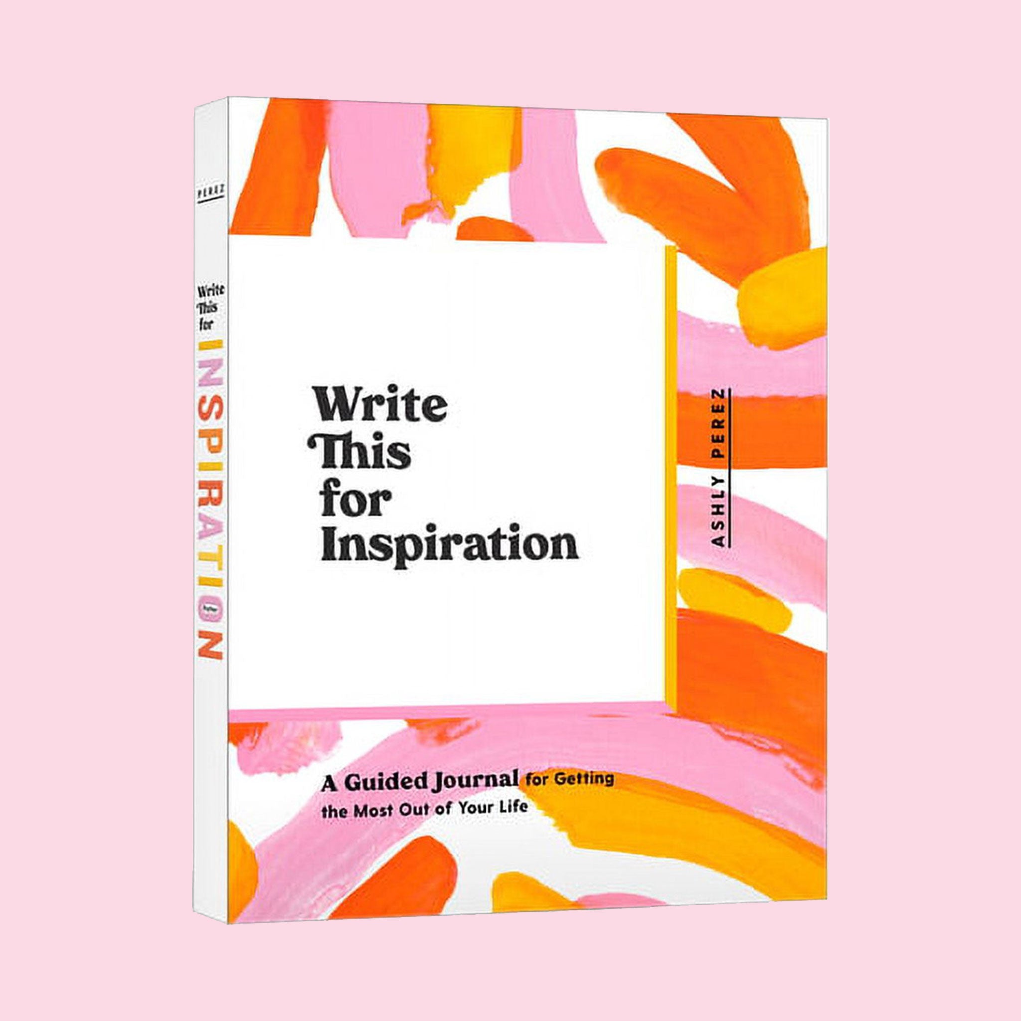 This journal is titled 'Write This for Inspiration by Ashly Perez' in black lettering and has an enjoyable free-hand painted design with shades of pinks and oranges on top of a white background. The binding of the book is also white with the title spelt out in similar colorful lettering.