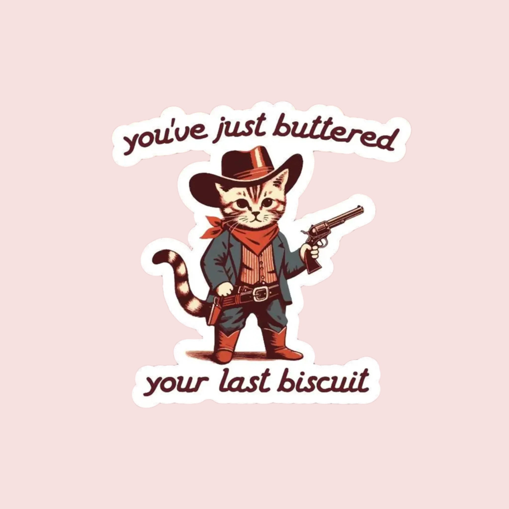 A sticker with an illustration of a kitty dressed up in a western cowboy outfit with text above and below that reads, 'you've just buttered your last biscuit'. 