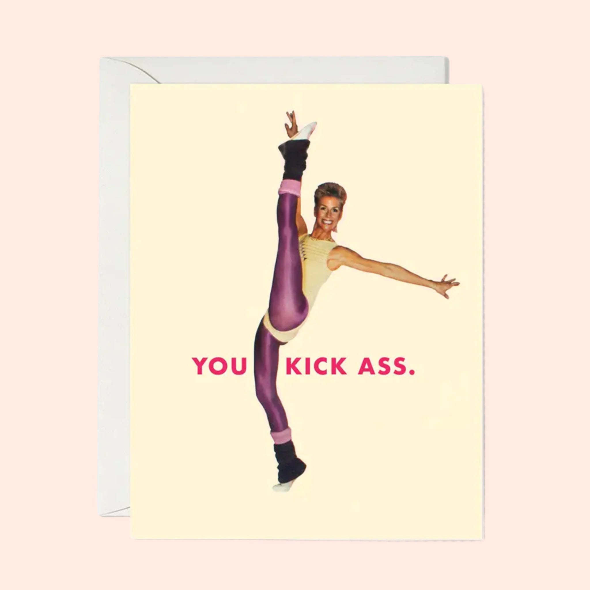 A neutral card that reads, &#39;You Kick Ass&#39; with a graphic of a woman doing a high kick wearing an 80&#39;s inspired workout  outfit. 