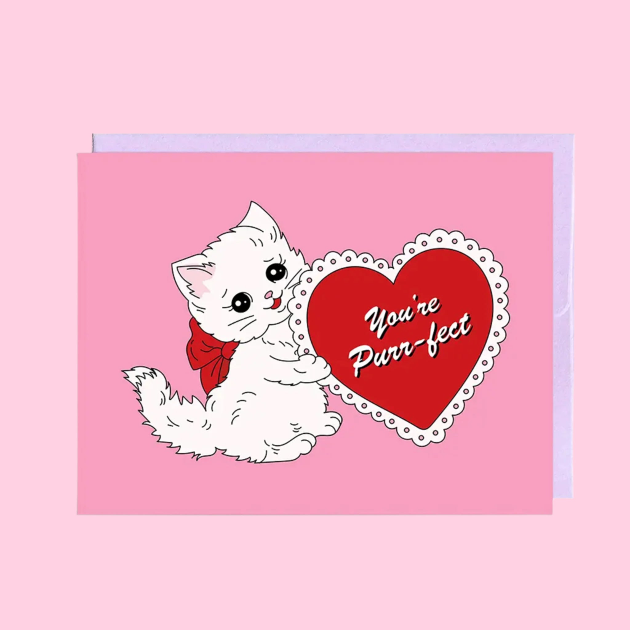 A bubblegum pink card with an illustration of a white cat with a red bow, holding a lace trimmed red heart that reads, &quot;You&#39;re Purr-fect&quot; in white cursive letters. Also photographed is the kraft brown envelope that is included with purchase.