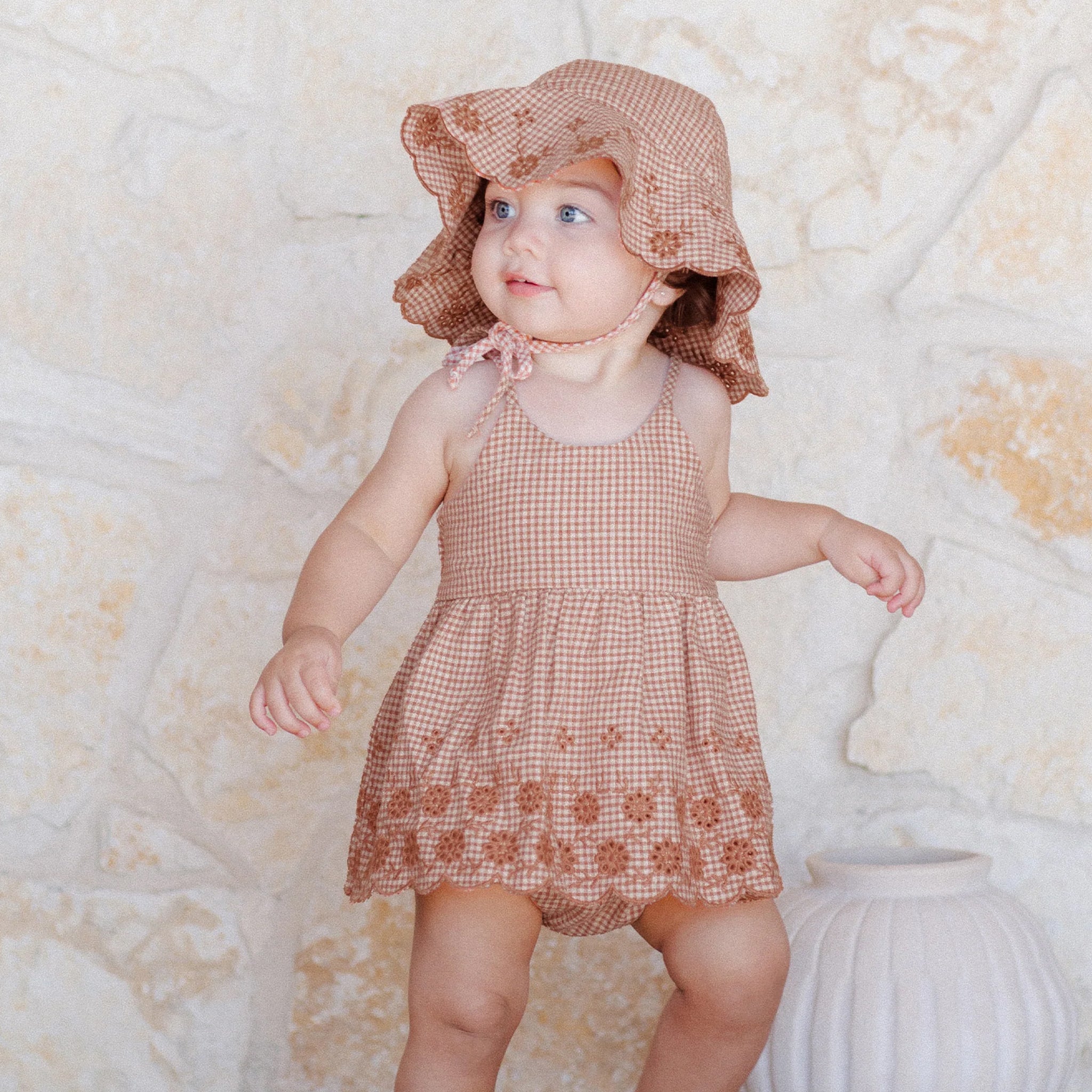 A red and white gingham print set with spaghetti straps and a floral cut out detail around the edge paired with bloomers. 