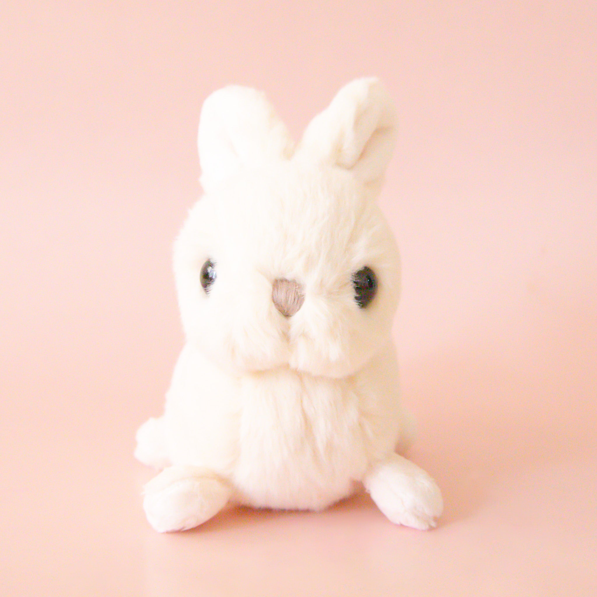 A white bunny shaped stuffed animal. 