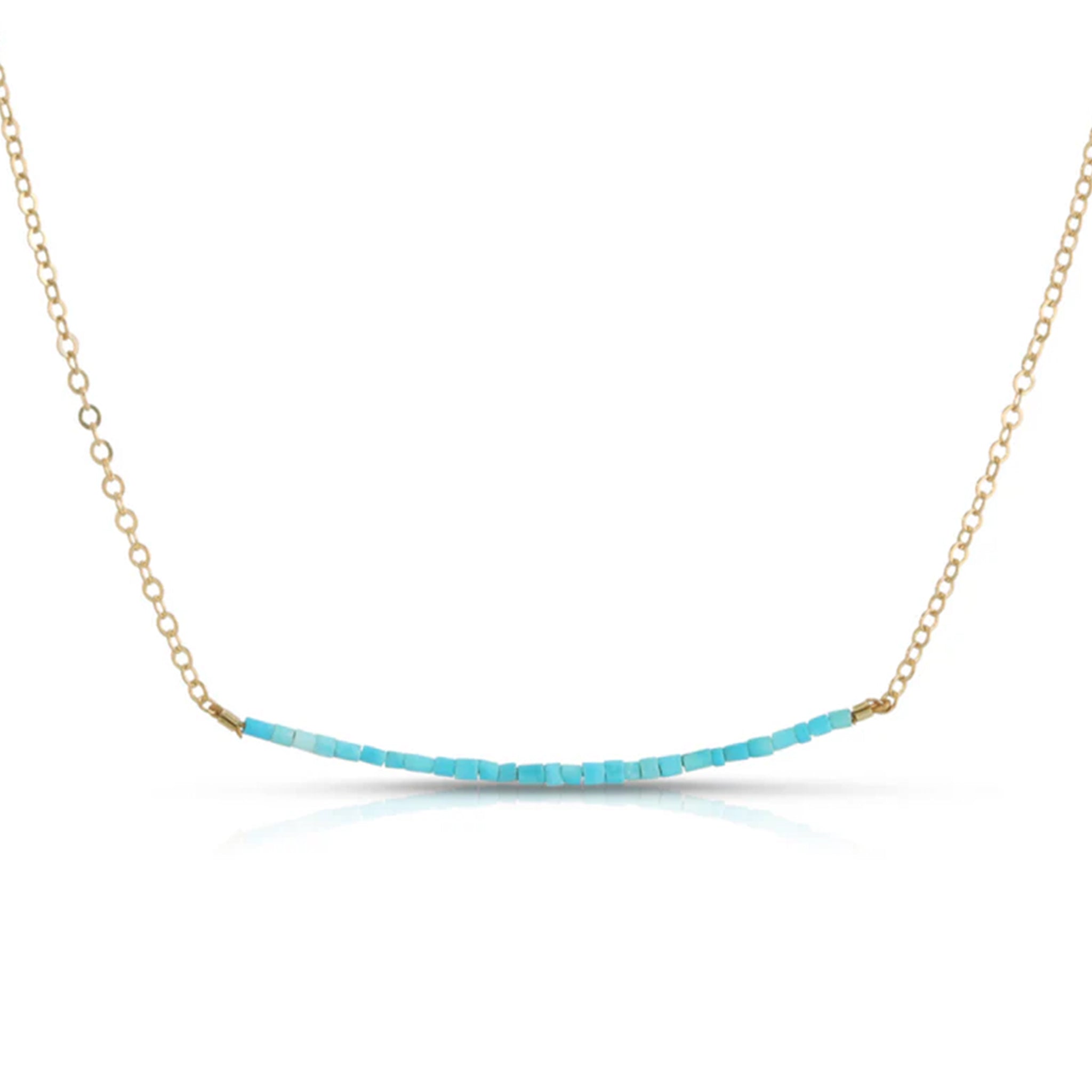 A gold chain necklace with blue turquoise beads horizontally along the chain. 