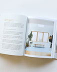 A book lays open on the table. Text fills the left page titles "Skylights", the right page shows a bright room with a large window.