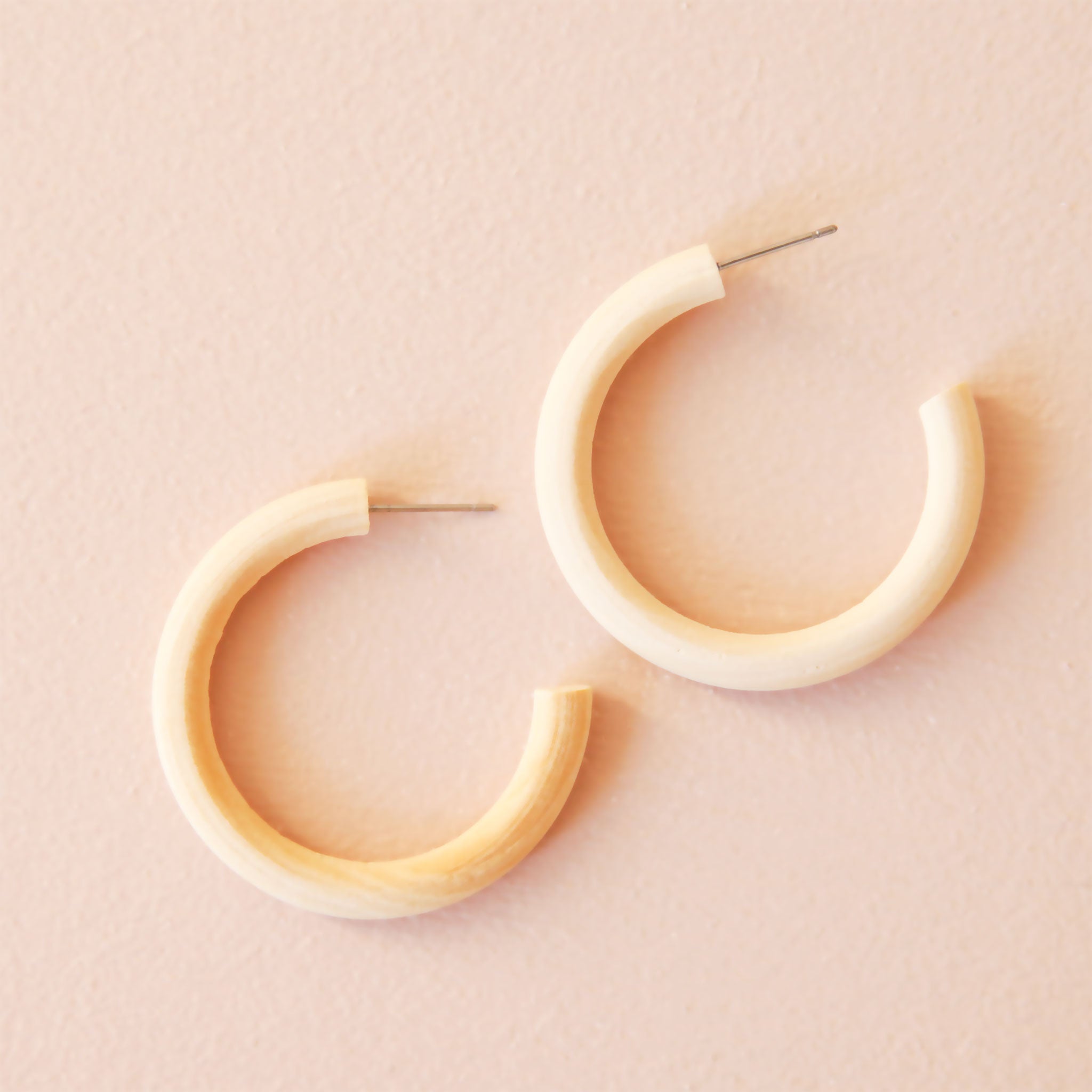 A natural wood hoop earring about 1.5" with a stainless steel post.