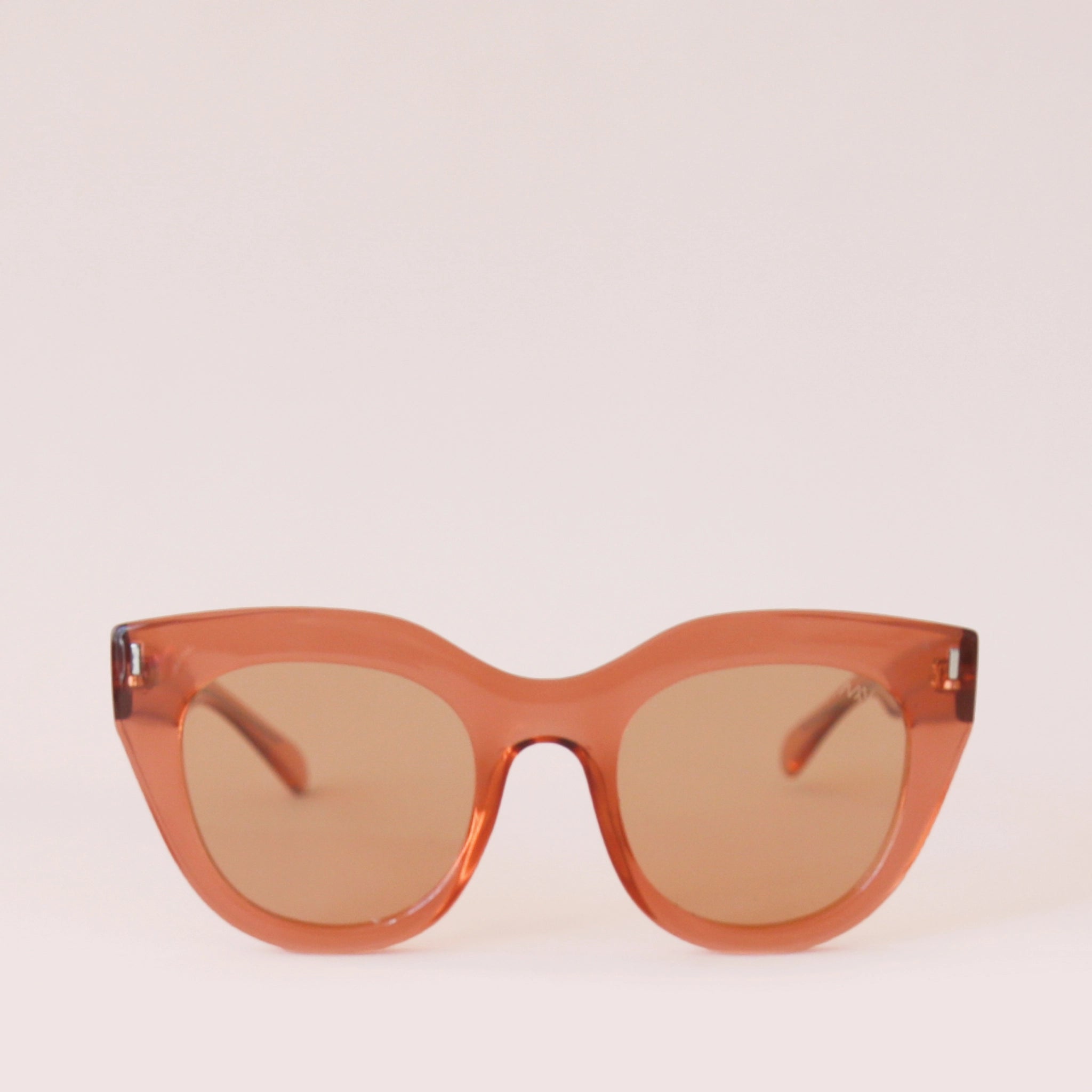 Orange sunglasses with a rounded edge and a slight cat eye shape along with orange lenses.