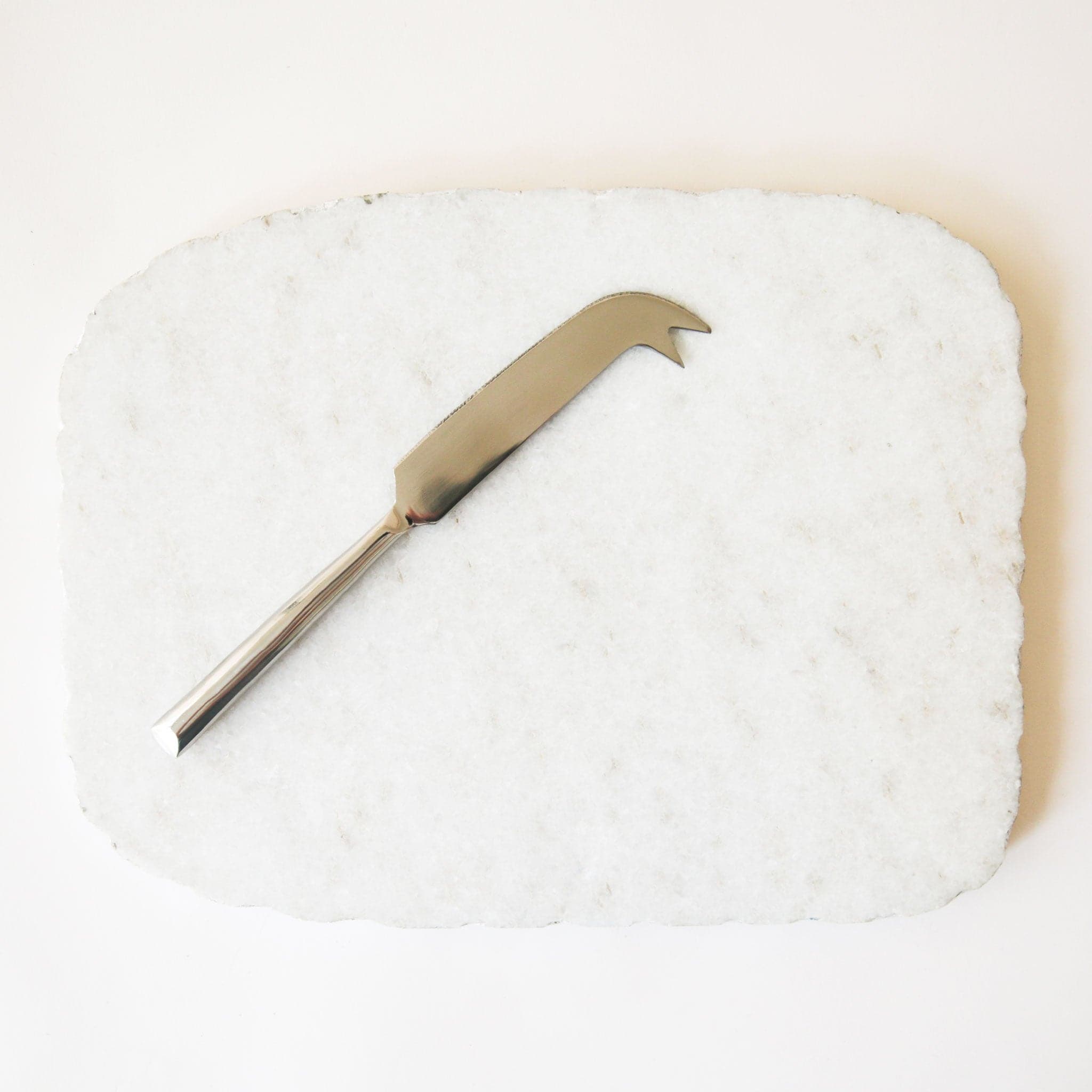  On a white background is a white marble cheese board with a cutting knife and a silver edge.