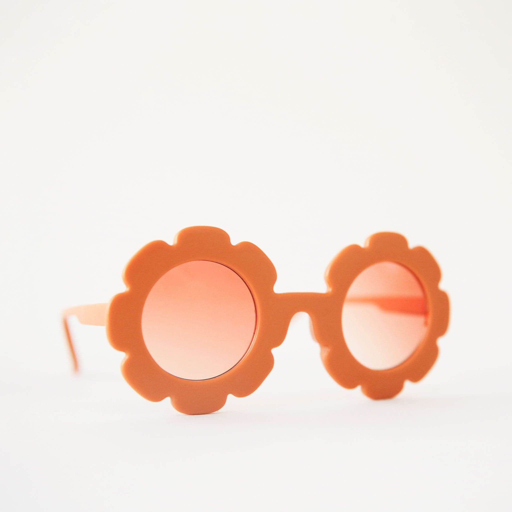 Orange flower shaped sunglasses with a light orange lens.