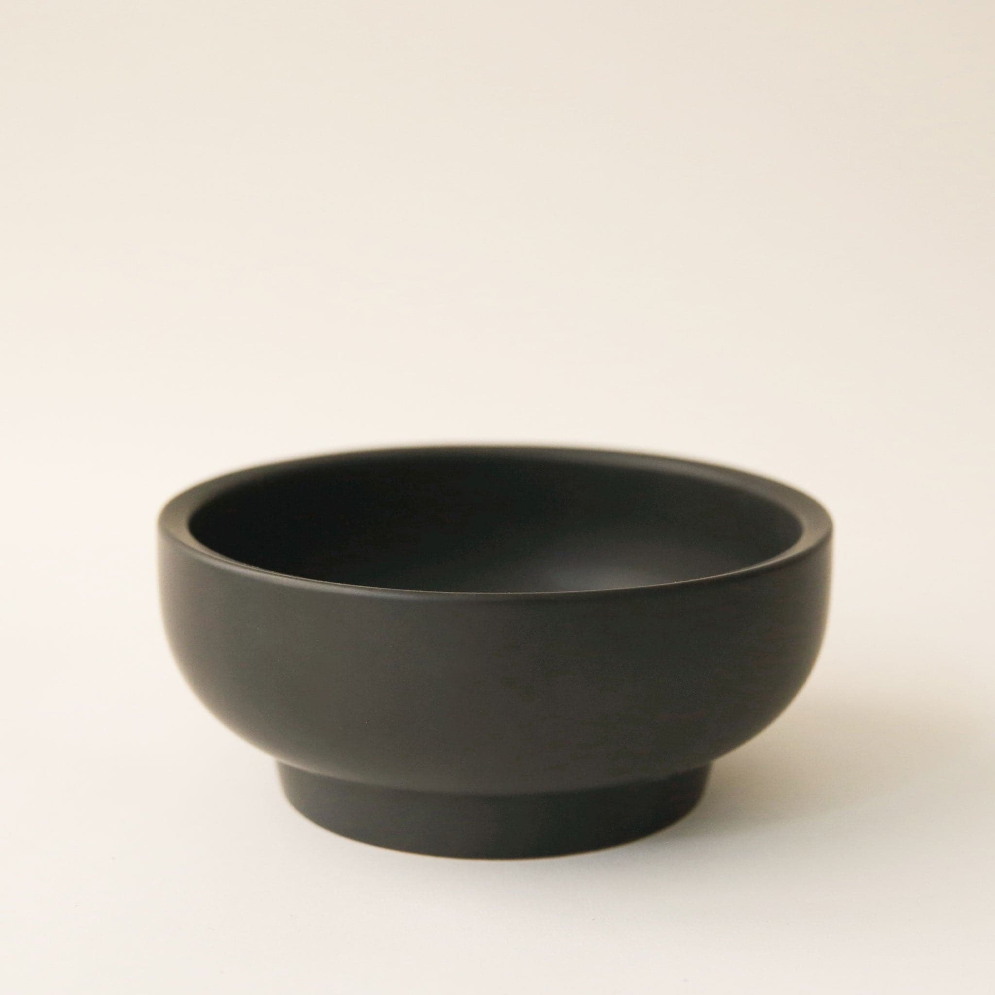 A black ceramic pedestal bowl.