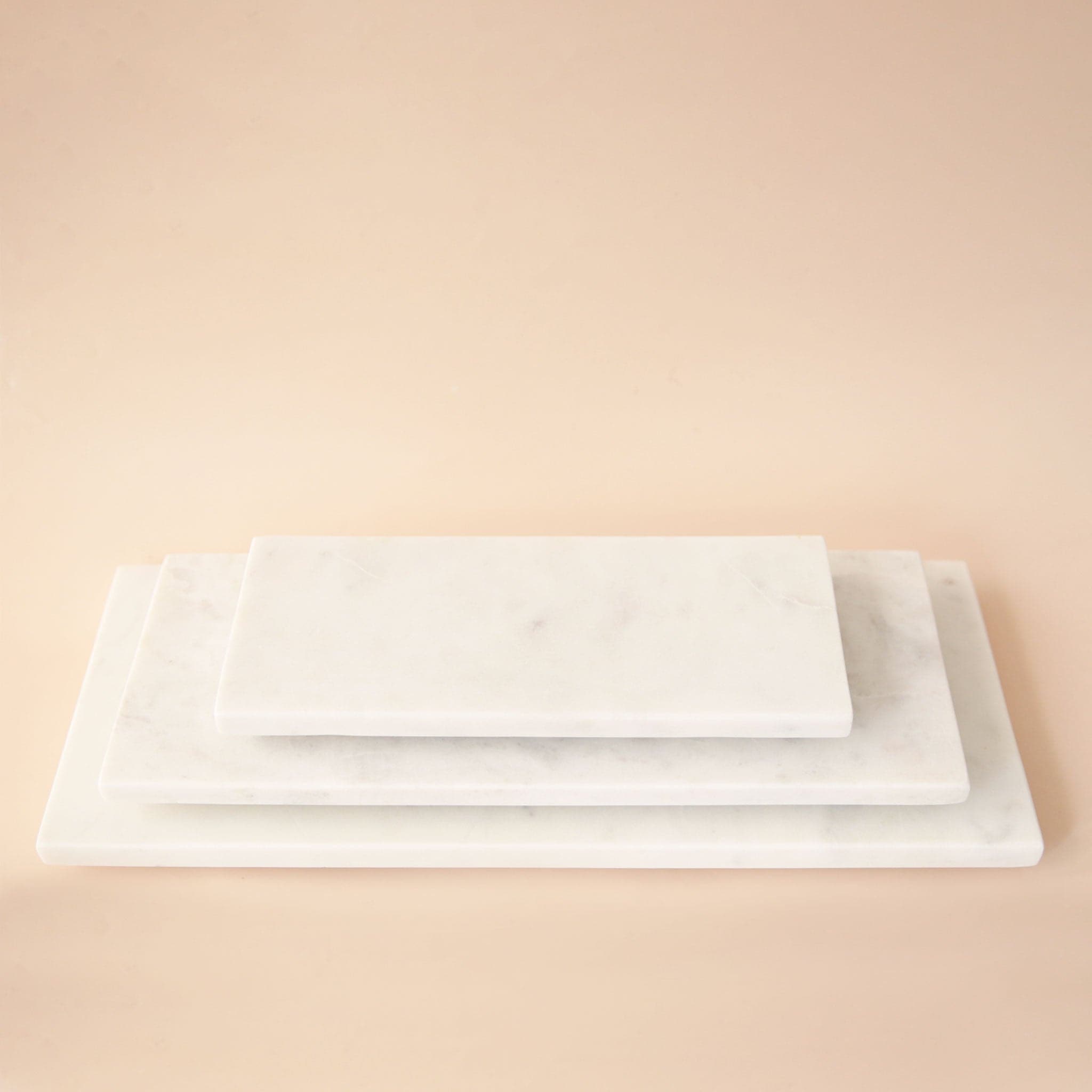 Three white marble trays in different rectangular sizes. Each tray sold separately.