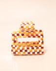 A white and brown acrylic checkered claw hair clip with a square shape and two simple geometric cutouts.
