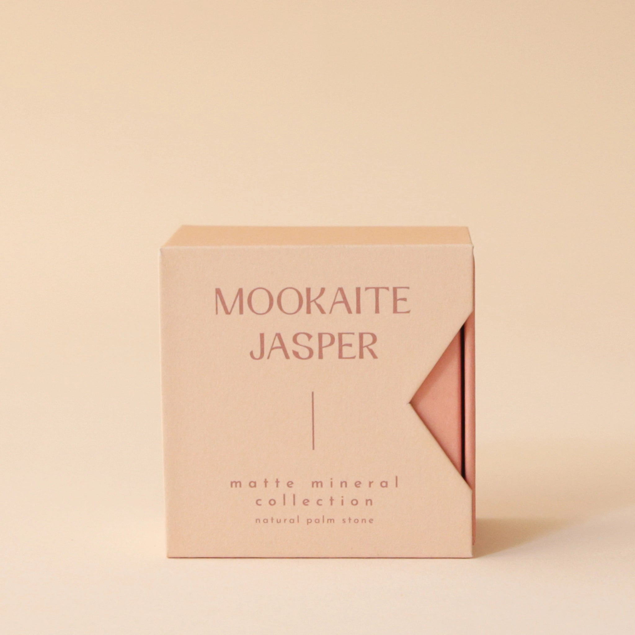 A salmon colored box that reads, &quot;Mookaite Jasper Matte Mineral Collection in rust colored letters.