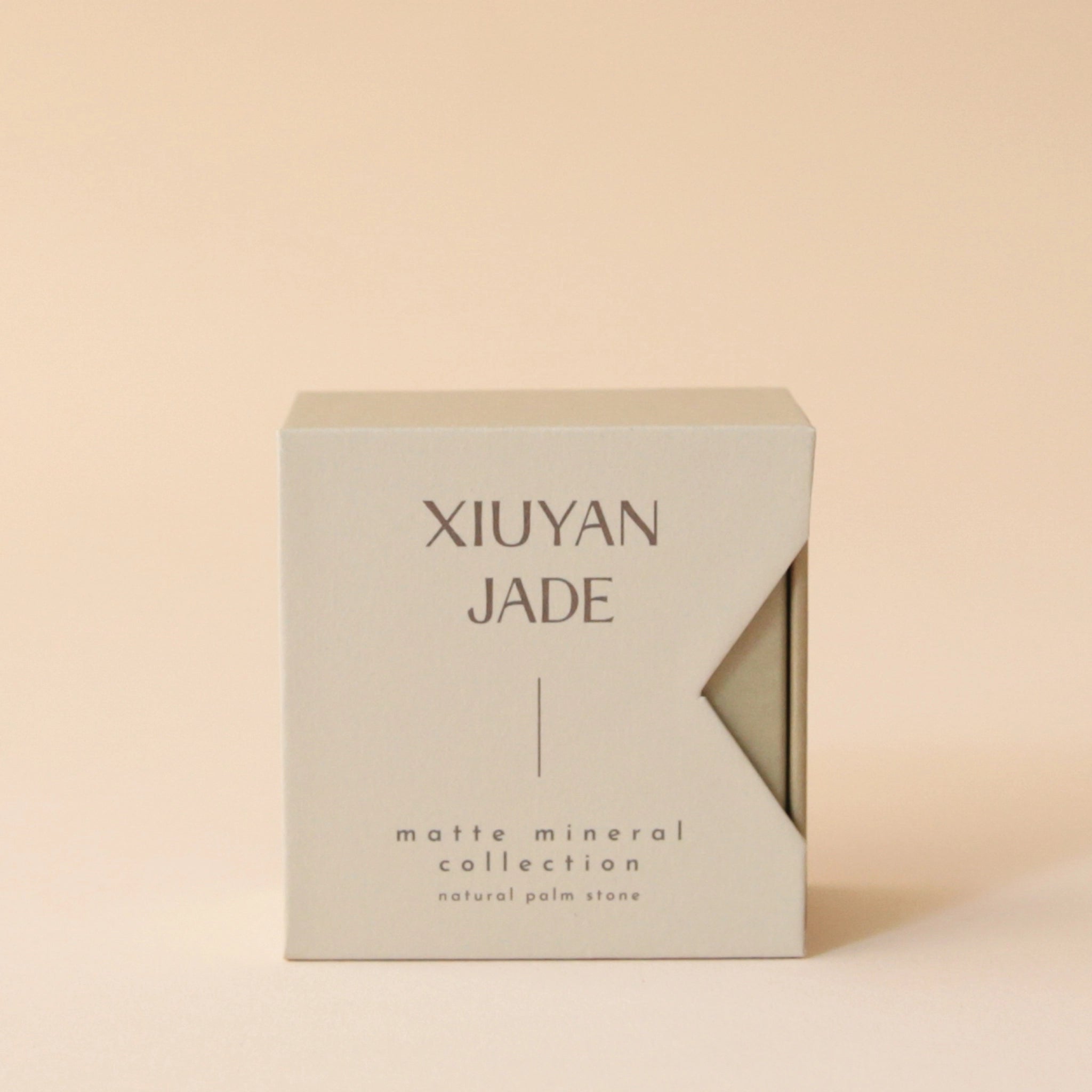 A neutral tan box that says, &quot;Xiuyan Jade Matte Mineral Collection&quot; in dark brown letters.