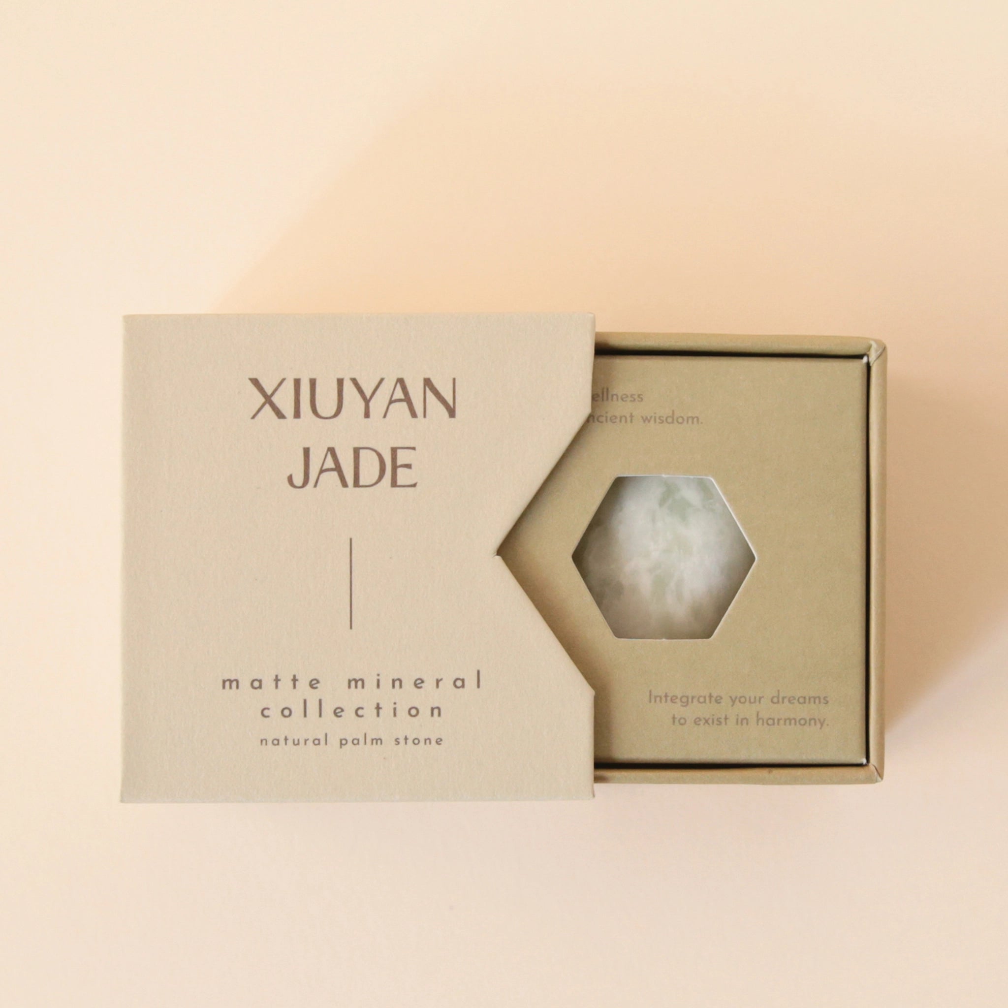 A neutral tan box that says, "Xiuyan Jade Matte Mineral Collection" in dark brown letters along with a white and light green Xiuyan Jade stone.