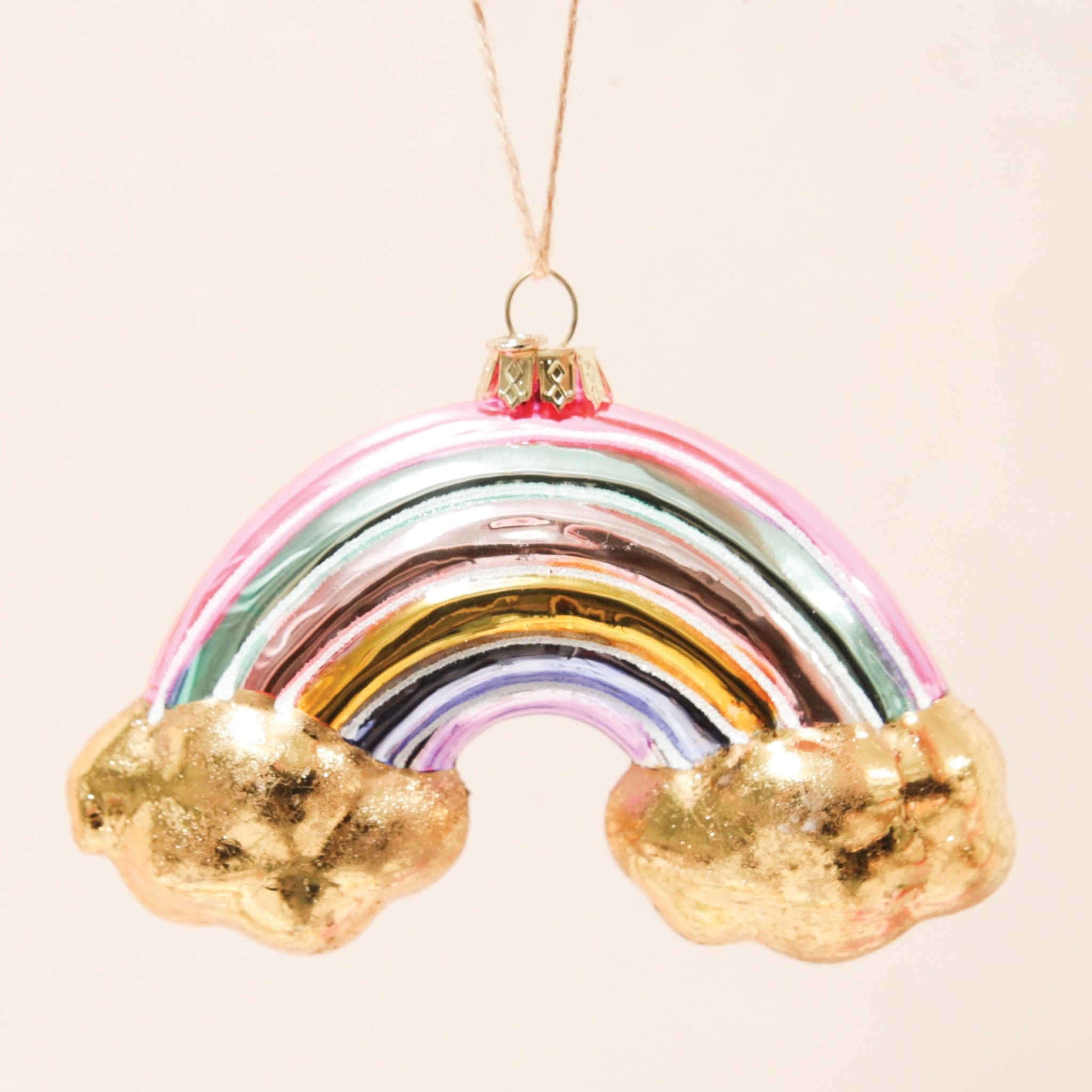 A glass rainbow ornament with gold clouds on the end of each side.