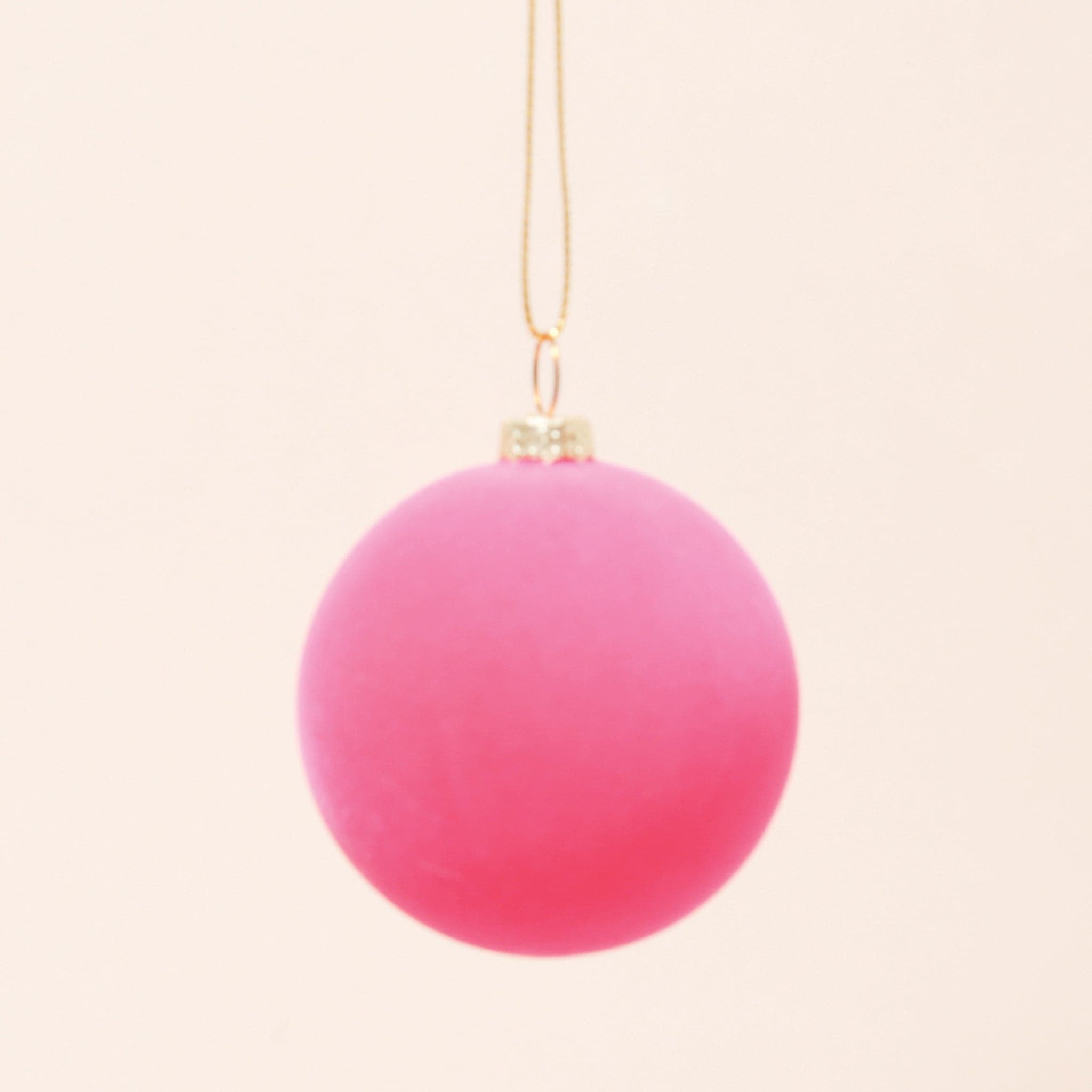 A classic ball ornament with a hot pink velvety finish, a gold clasp holding a gold loop that&#39;s about 3&quot; for hanging.