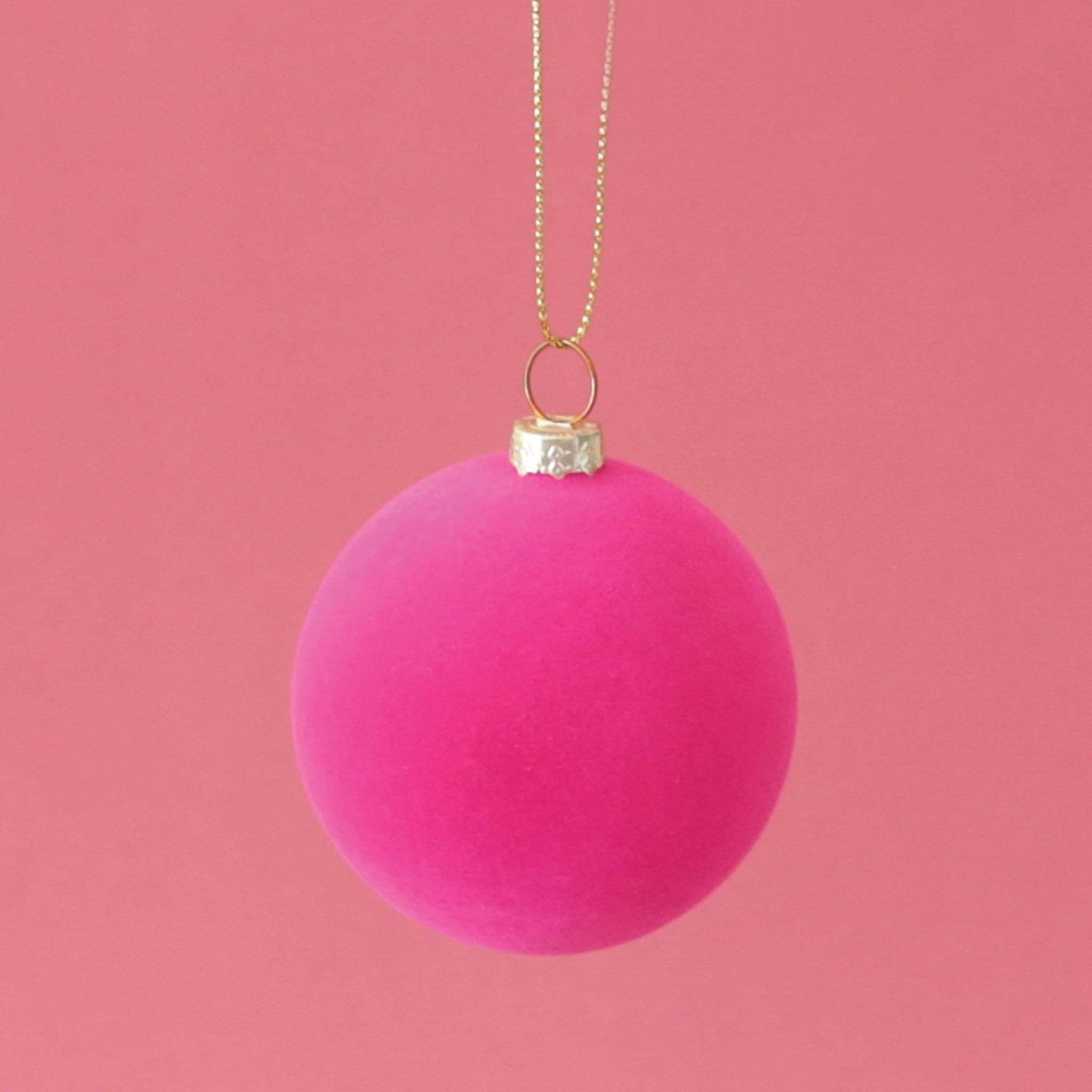 A classic ball ornament with a hot pink velvety finish, a gold clasp holding a gold loop that&#39;s about 3&quot; for hanging.