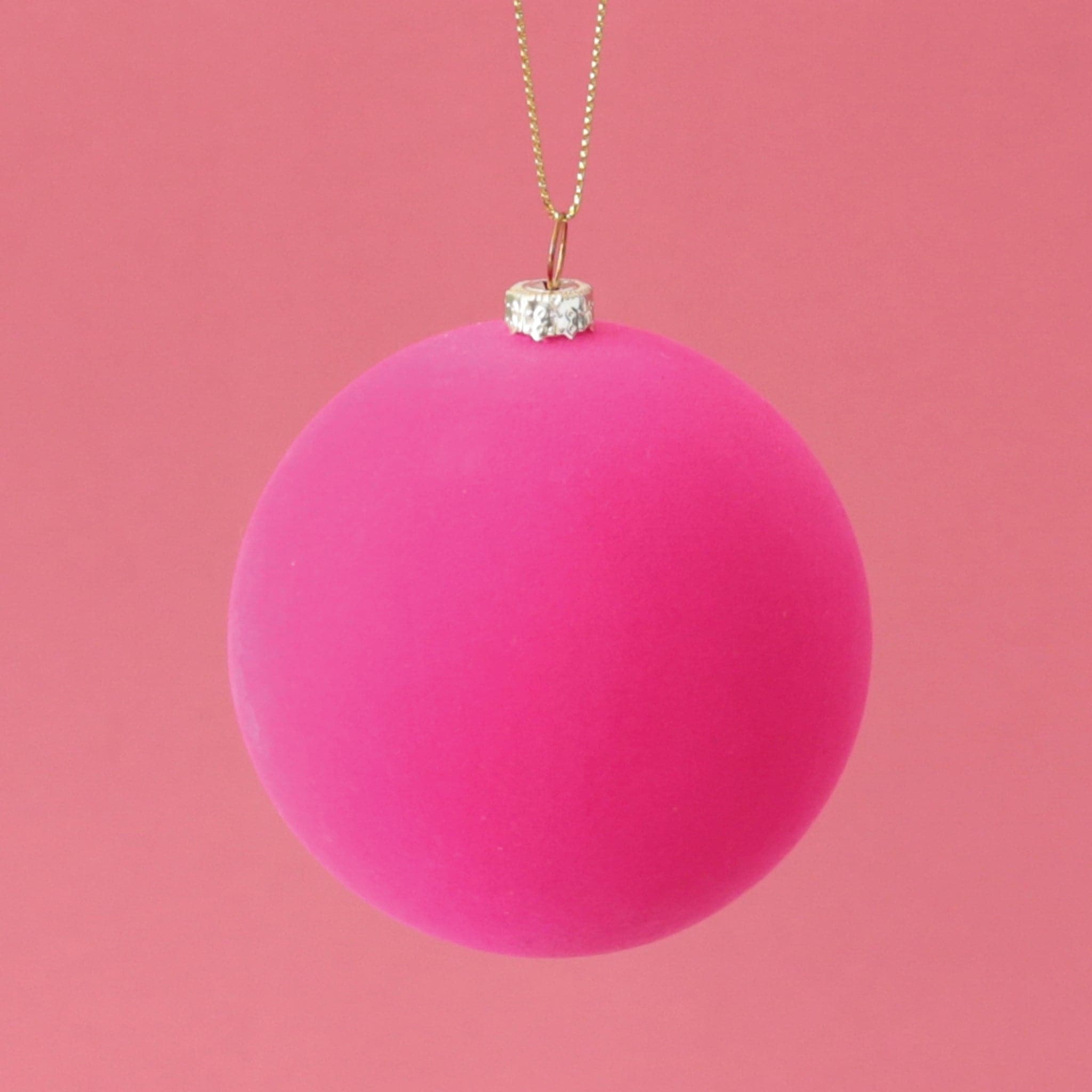 A classic ball ornament with a hot pink velvety finish, a gold clasp holding a gold loop that&#39;s about 3&quot; for hanging.