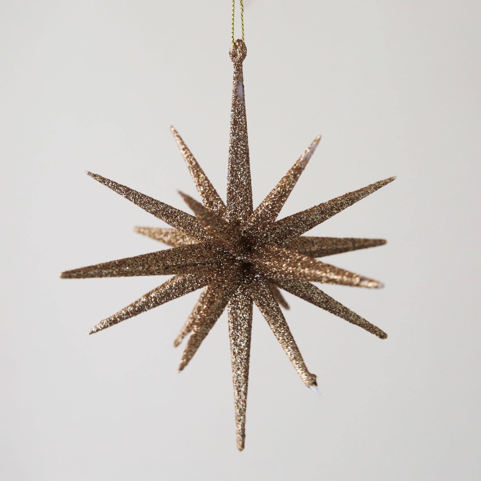 A 16 pointed gold glitter starburst ornament.