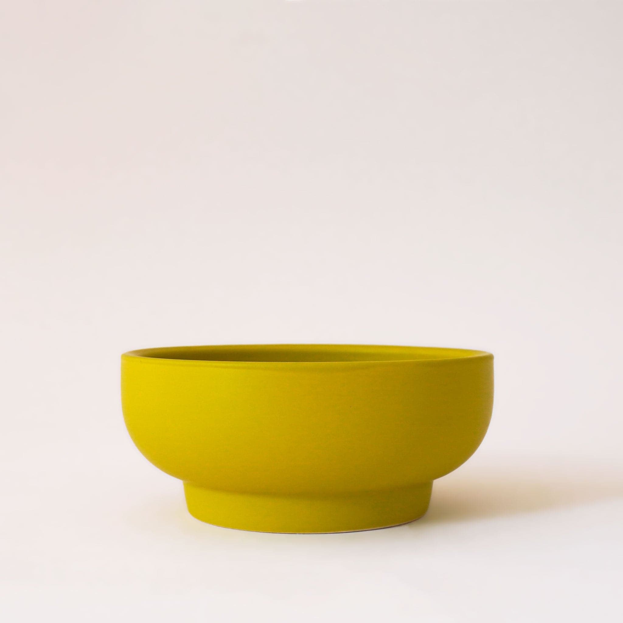 Chartreuse green bowl planter that tapers towards the base.