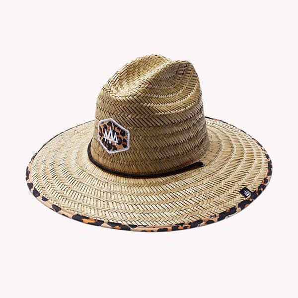 Against a white background is the top view of a wide brim, straw hat. The brim has a black and brown cheetah print border. On the front of the hat is a cheetah print diamond with three white trees inside. The black drawstring goes around half of the top of the hat.