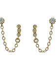 A pair of stud earrings with a chain connecting to another stud earring.