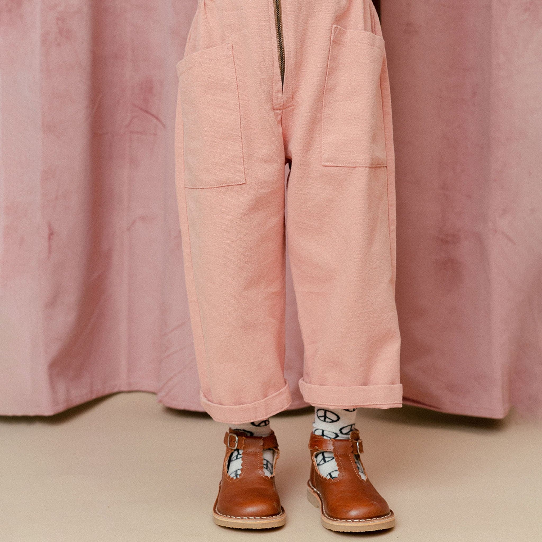 A short sleeved utility jumpsuit in the sweetest dusty rose shade. There is a front zipper and a two pockets.