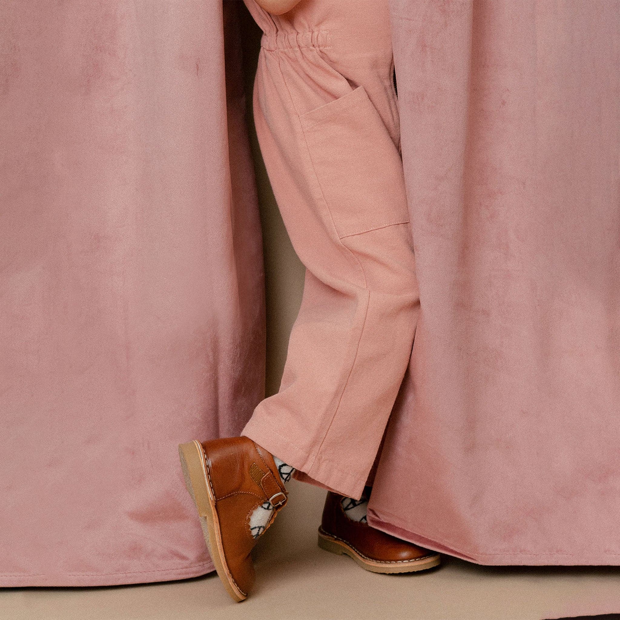 A short sleeved utility jumpsuit in the sweetest dusty rose shade. There is a front zipper and a two pockets.