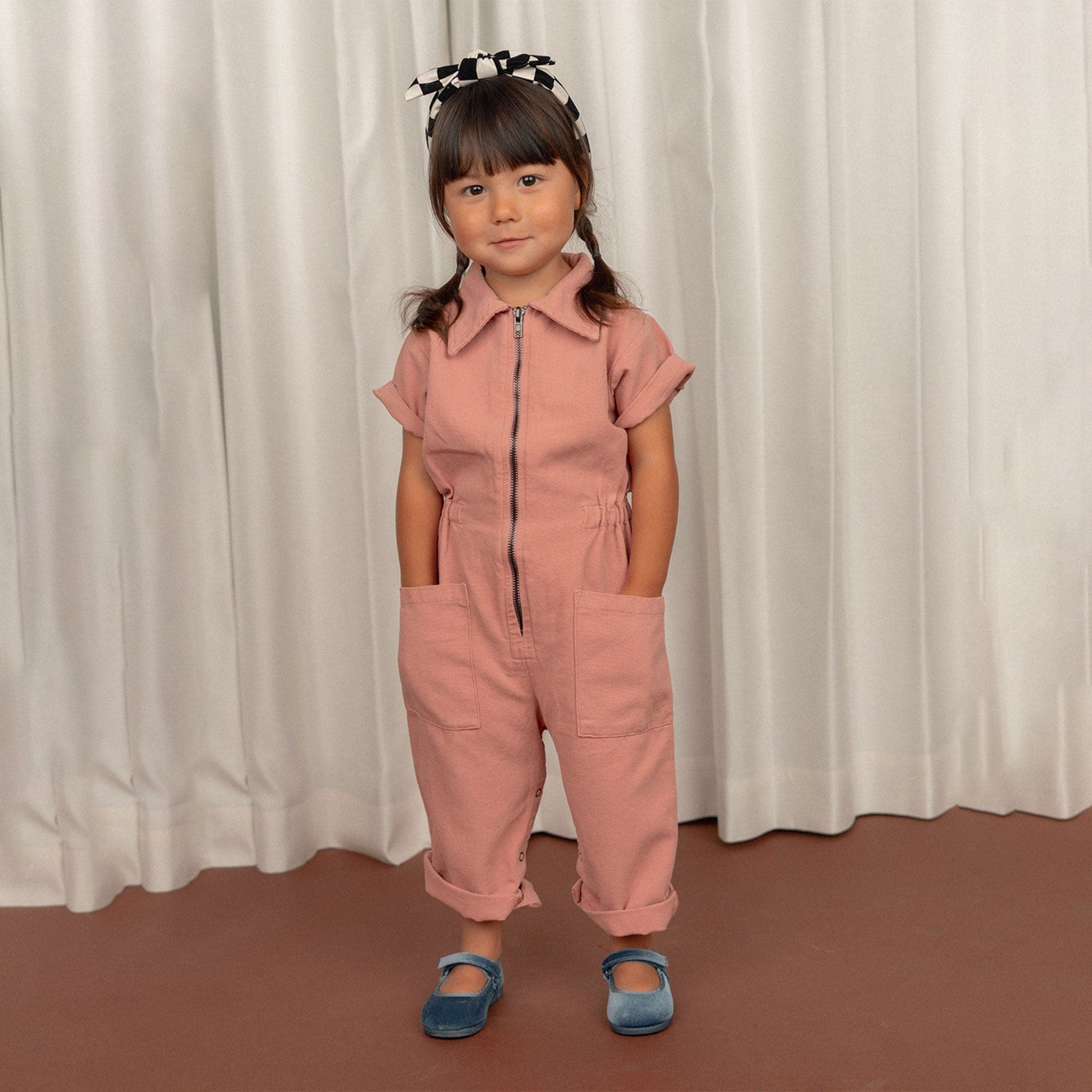 A short sleeved utility jumpsuit in the sweetest dusty rose shade. There is a front zipper and a two pockets.