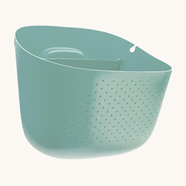 On a white background is a light blue self watering wall planter with small holes in the front, an opening in the back for holding water. 