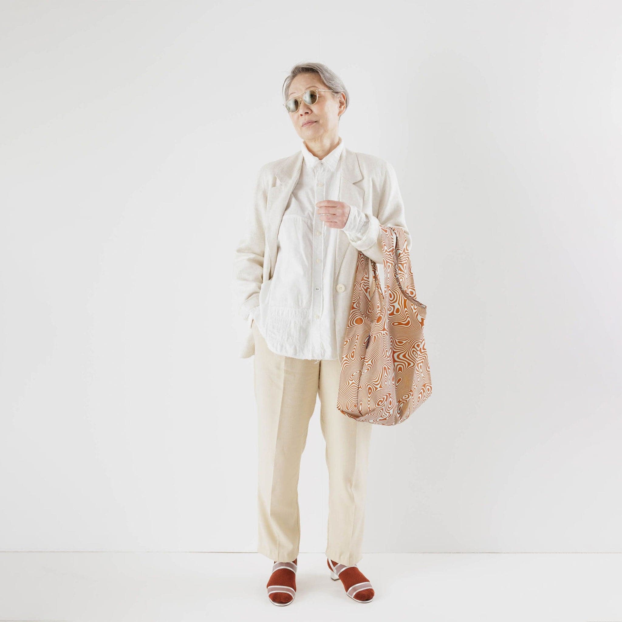 A nylon bag with an orange and cream wavy swirl pattern all over.