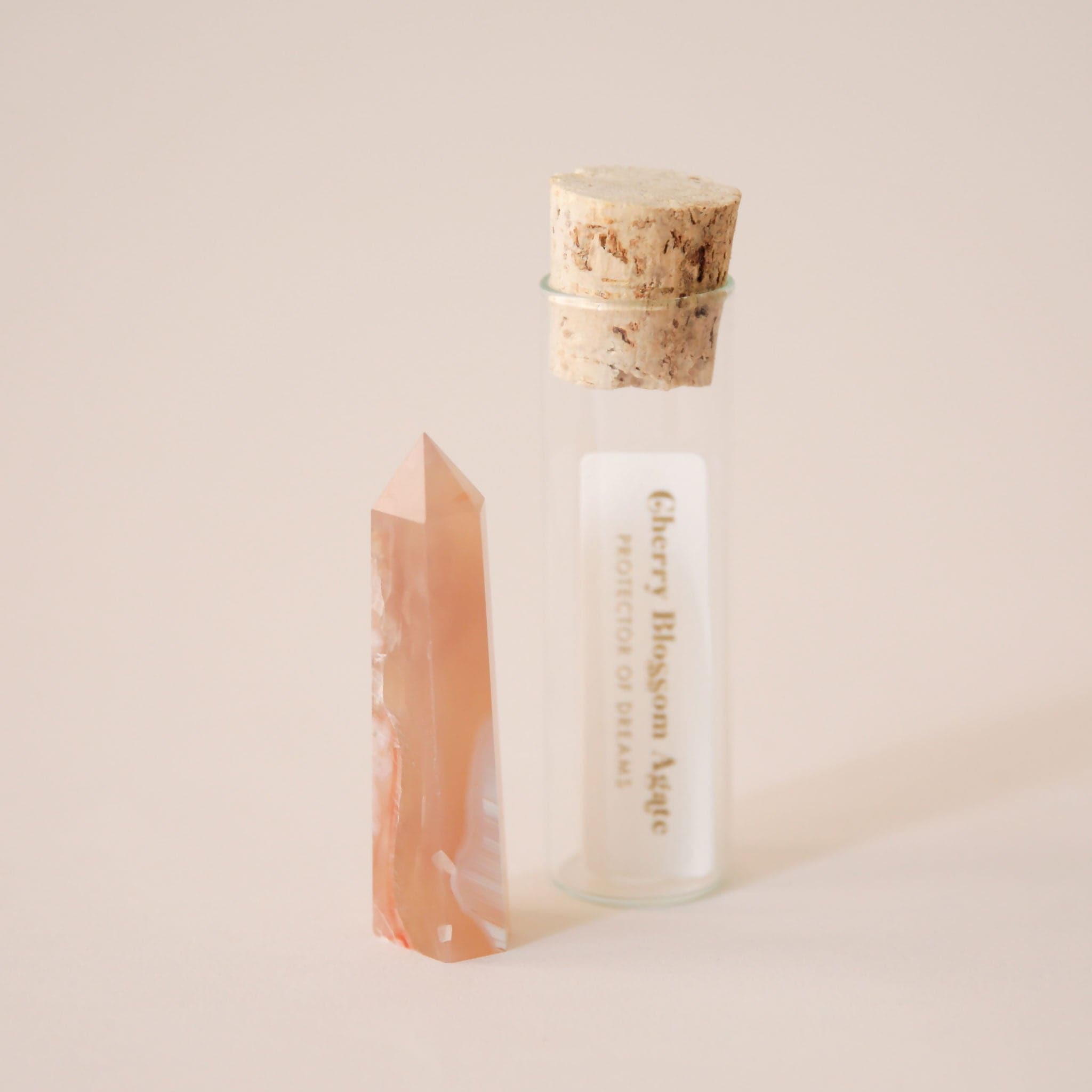 A photo of our packaging that each crystal is sold in. A glass tube holds the crystal while the top is secured by a round cork. The packaging also includes a paper with the name of the crystal and its general meaning and purpose.