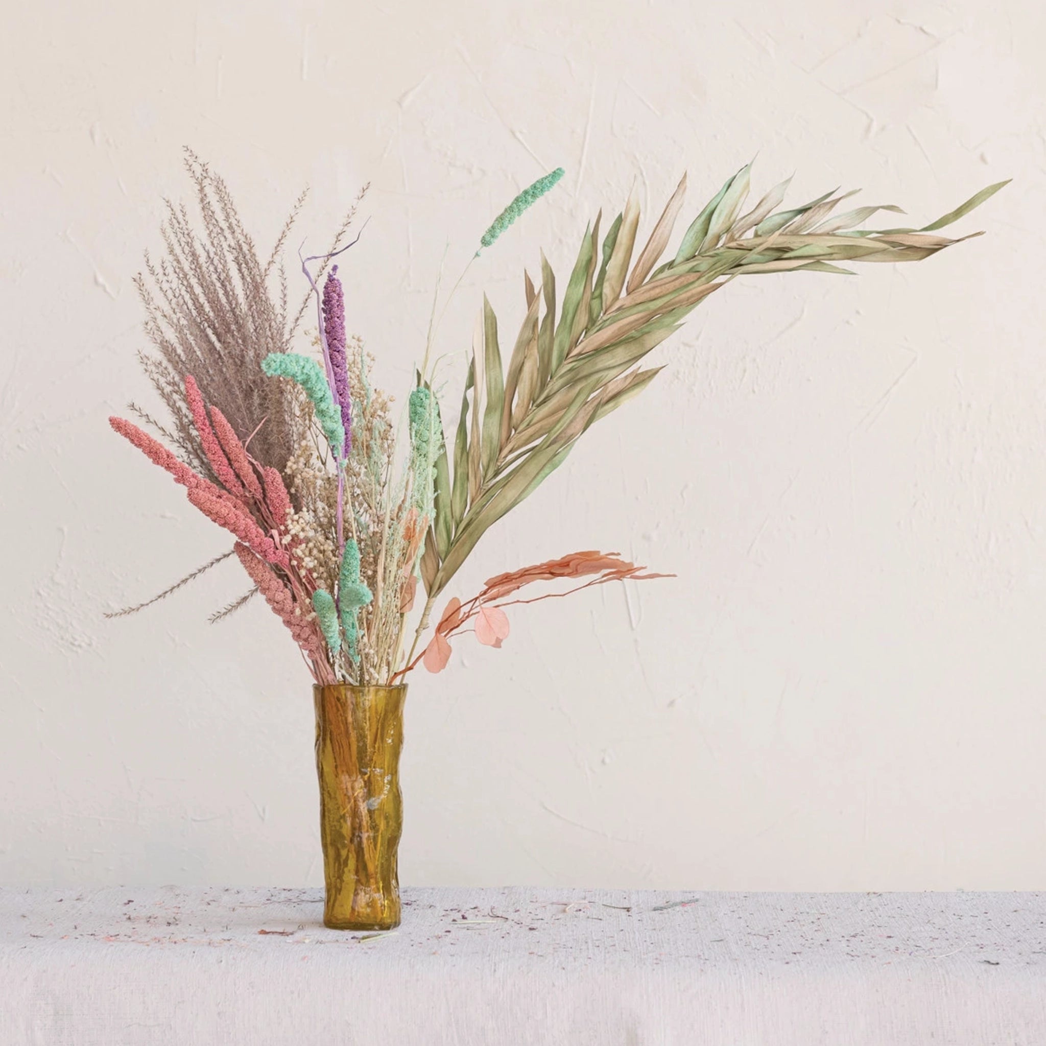 A bundle of dried foxtail florals in a pink shade photographed in an arrangement.