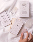 A cream box of 78 Tarot cards with an illustration of two hands and a star in between. All cards are beautifully illustrated with descriptions underneath and detailed with gold foiling.