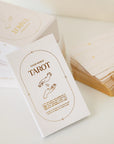 A cream box of 78 Tarot cards with an illustration of two hands and a star in between. All cards are beautifully illustrated with descriptions underneath and detailed with gold foiling.