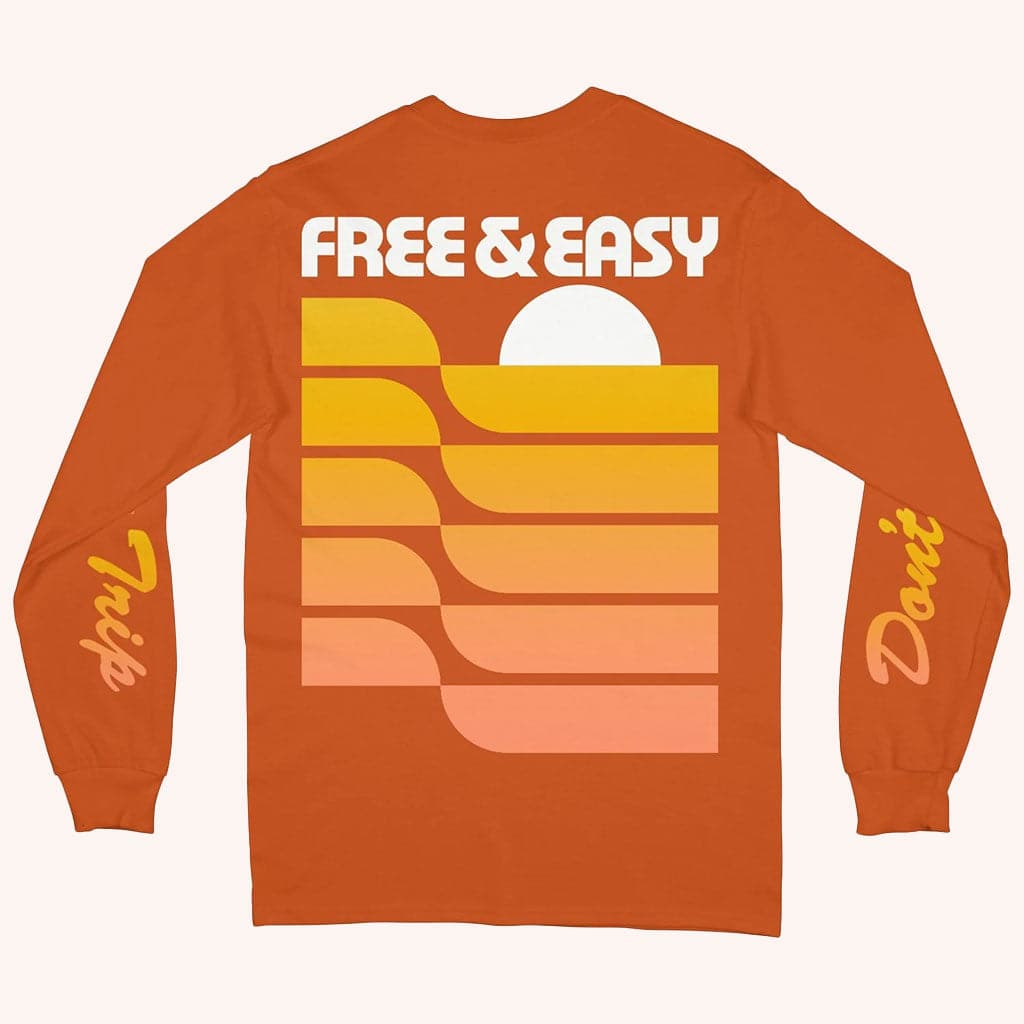 An orange long sleeve shirt with "Free & Easy" along with a yellow and light peach graphic design on the back. 