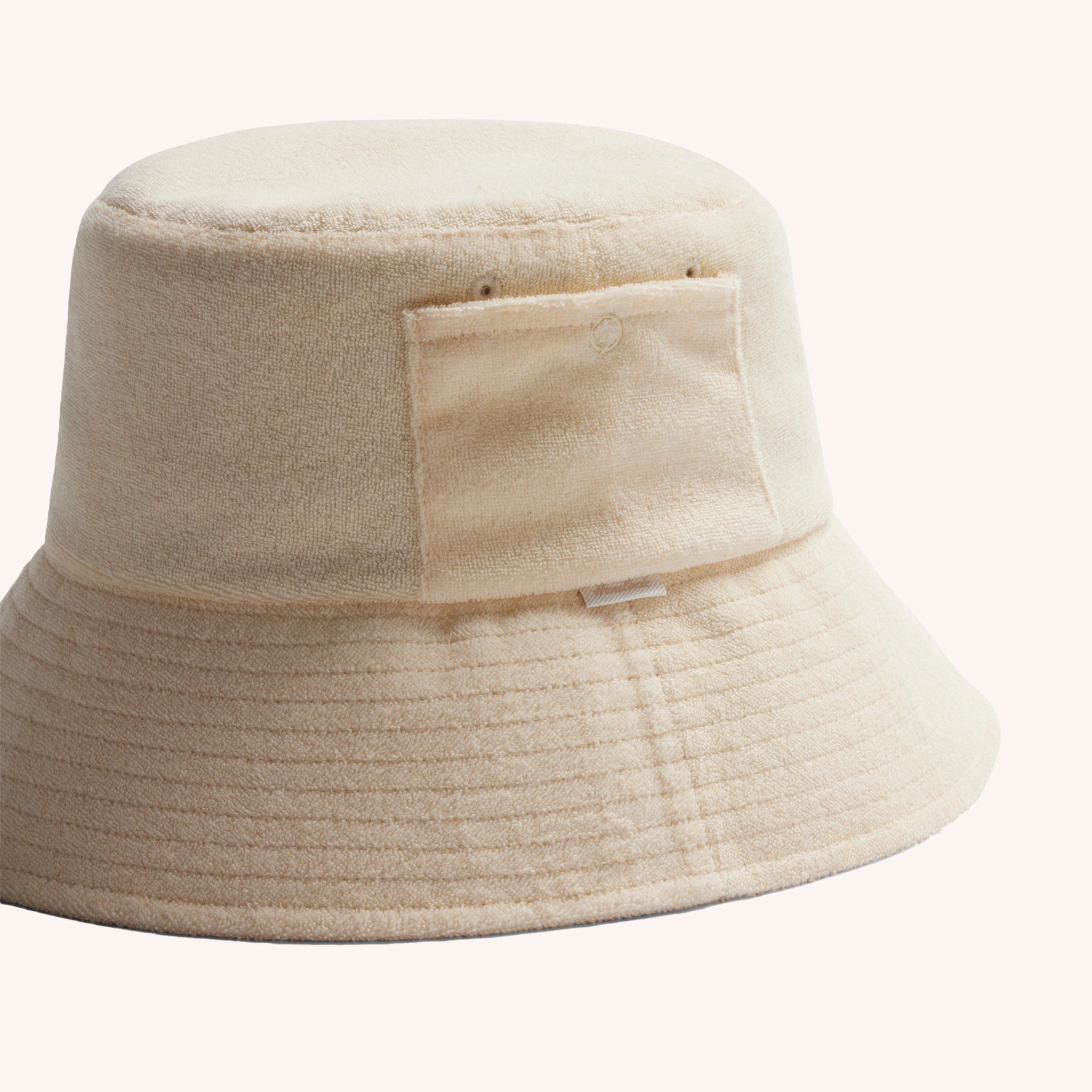 An ivory cotton bucket hat with a ribbed brim and a single side pocket.