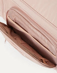 A nude colored pet carrier with an outside pocket for storing essentials and a zipper opening on both ends along with a handle on the top and two attachments for a shoulder strap option. There is a mesh opening on the side of the carrier that can also be covered with a folded flap.
